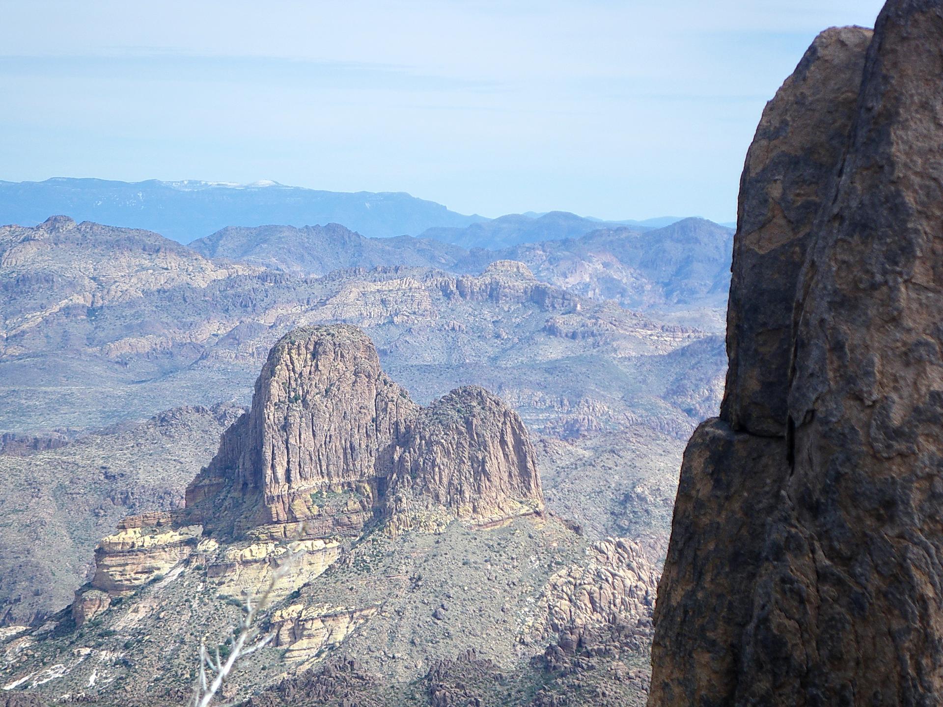 Towering rock formations dominate a rugged mountain desert landscape.