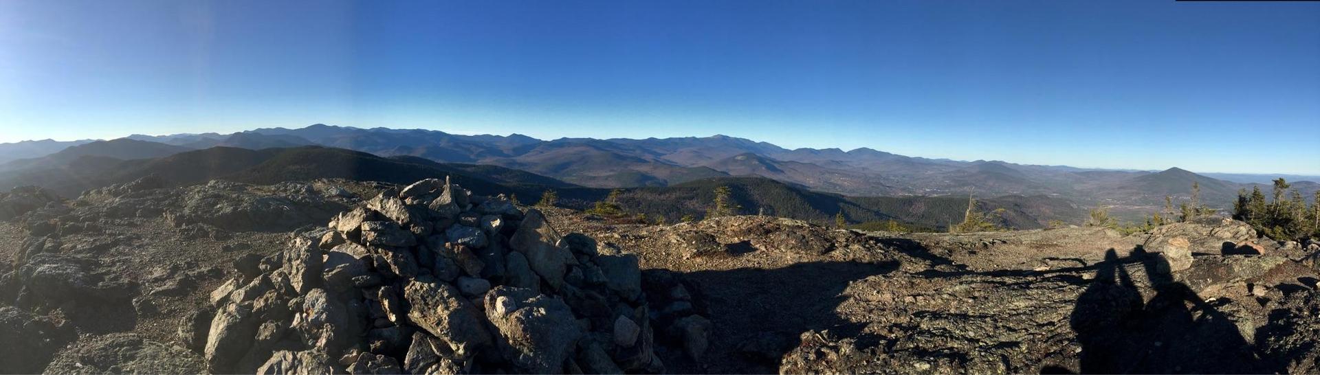 Panoramic view of a vast mountain range under a clear, sunny sky.