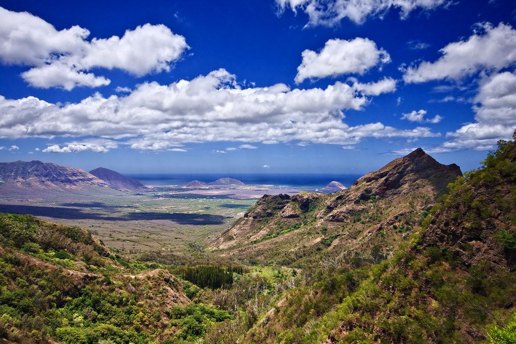 Sunny view of a deep valley, lush mountains, and ocean horizon with white clouds. - Kuilioloa Heiau to Kolekole Pass