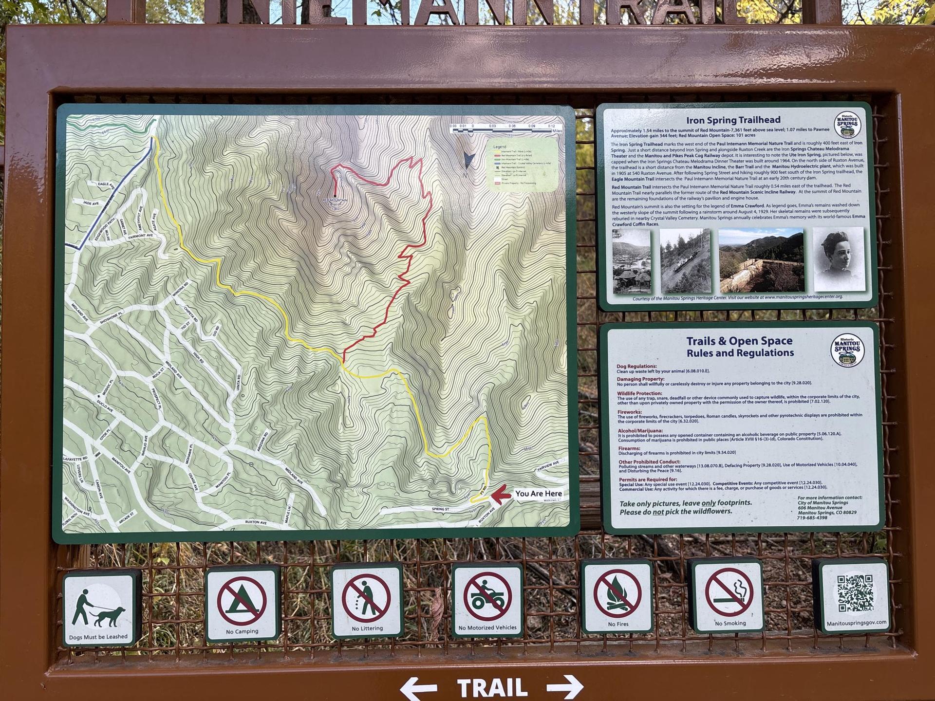 An outdoor information board displays a trail map, rules, and regulations.