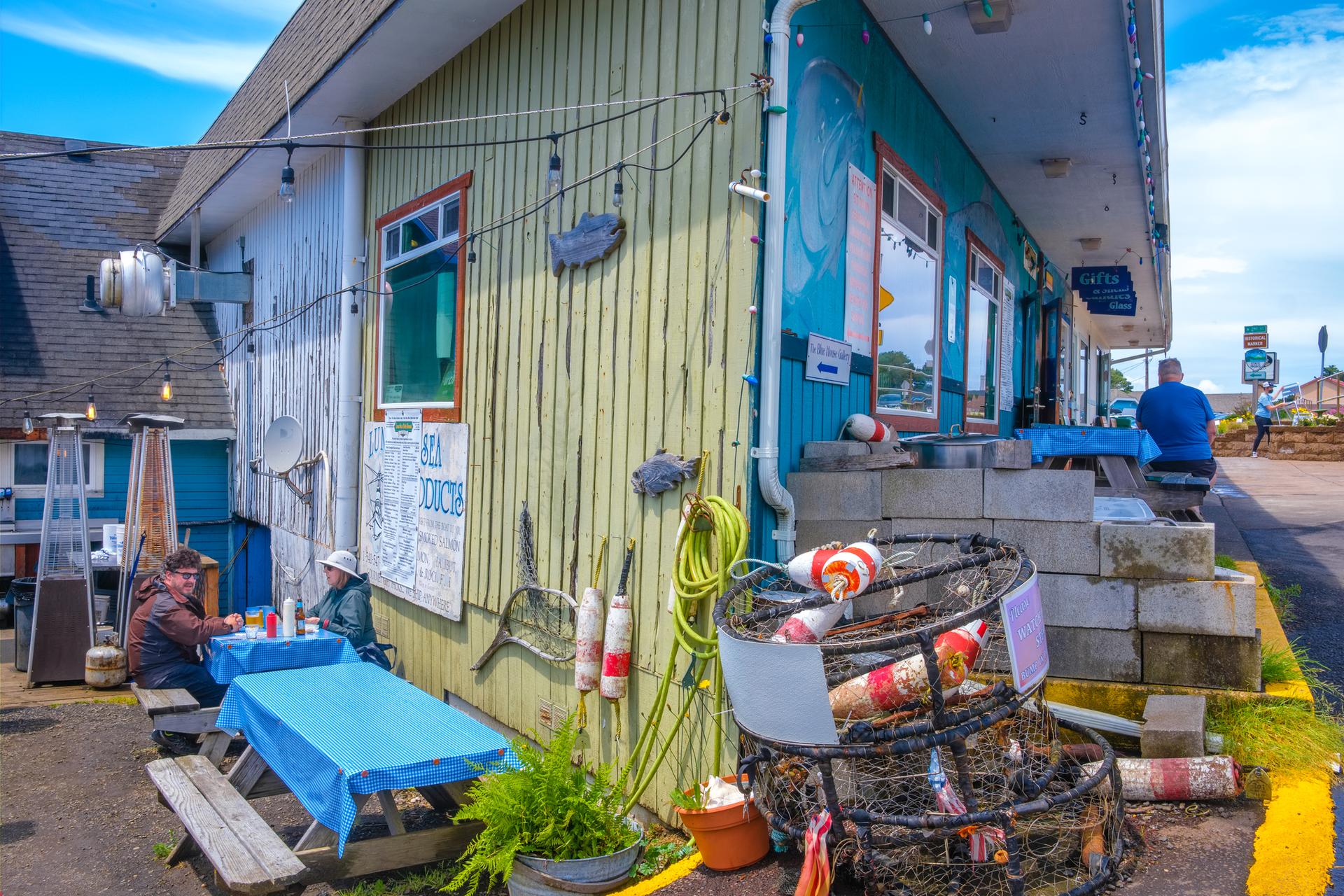 Colorful building with outdoor seating, people relaxing on a bright day.