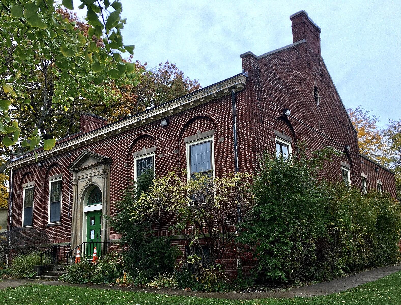 A large brick building with a green door under an overcast sky.