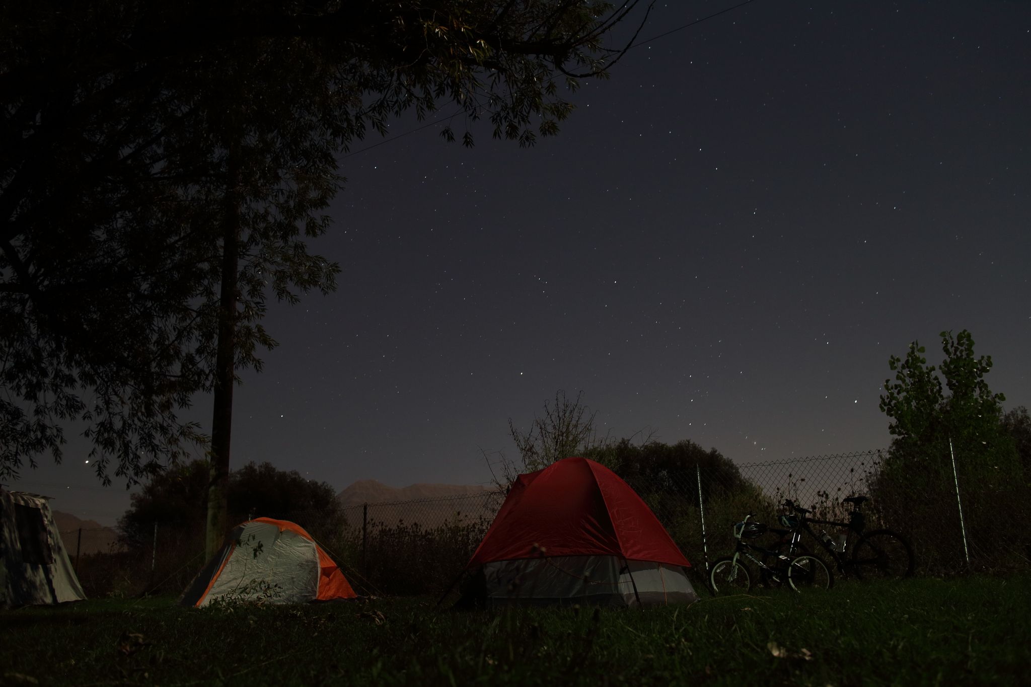 Two tents and bicycles under a dark, star-filled night sky. - Jordan River Parkway Trail