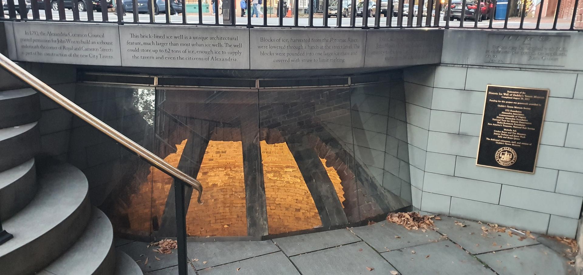 Stone stairs leading to an underground exhibit with warm light.