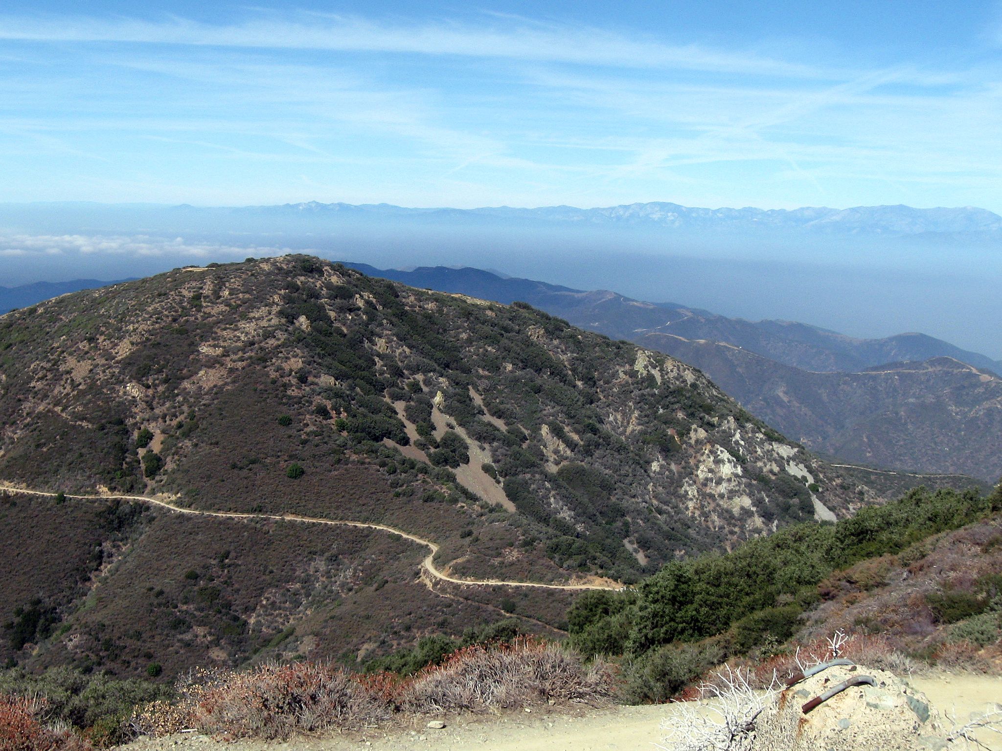 A winding dirt road traverses arid mountains under a clear sky. - Modjeska Peak via Joplin Trail