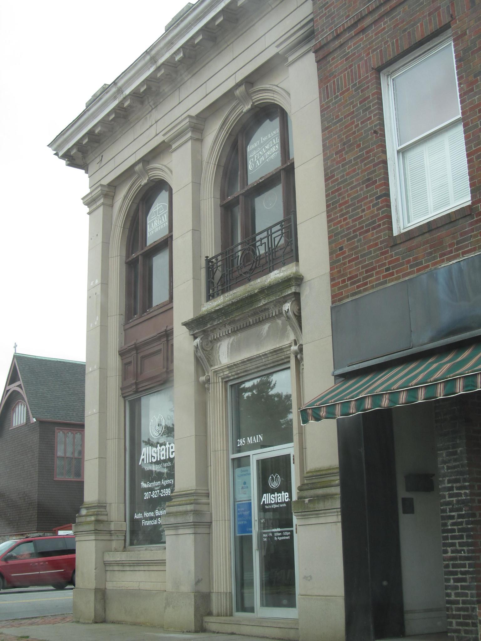 Old stone and brick building with arched windows on an overcast day.