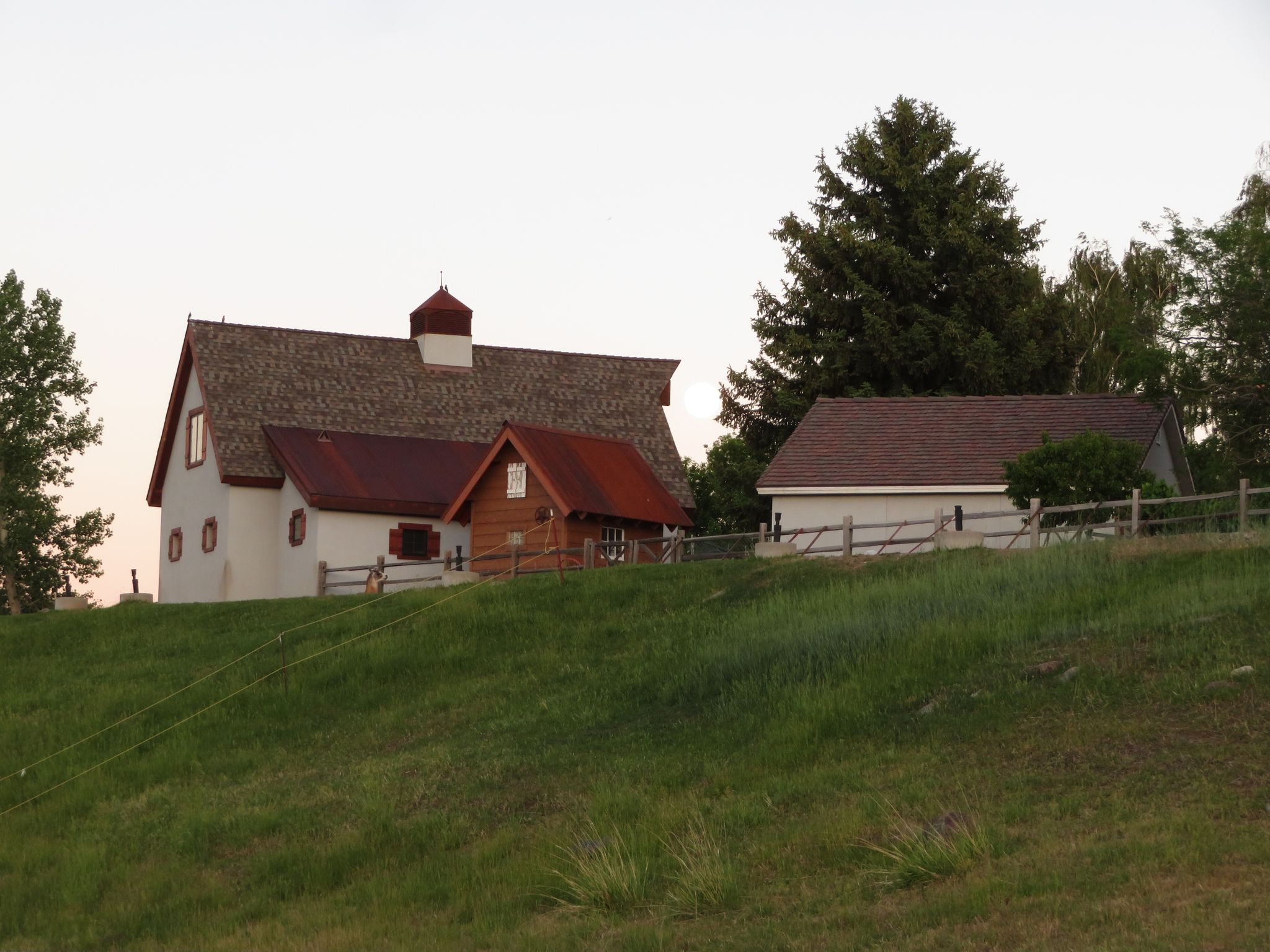 Two rustic buildings with red roofs on a grassy hill under a bright sky. - Tahoe-Pyramid Bikeway and Caughlin Ranch Loop