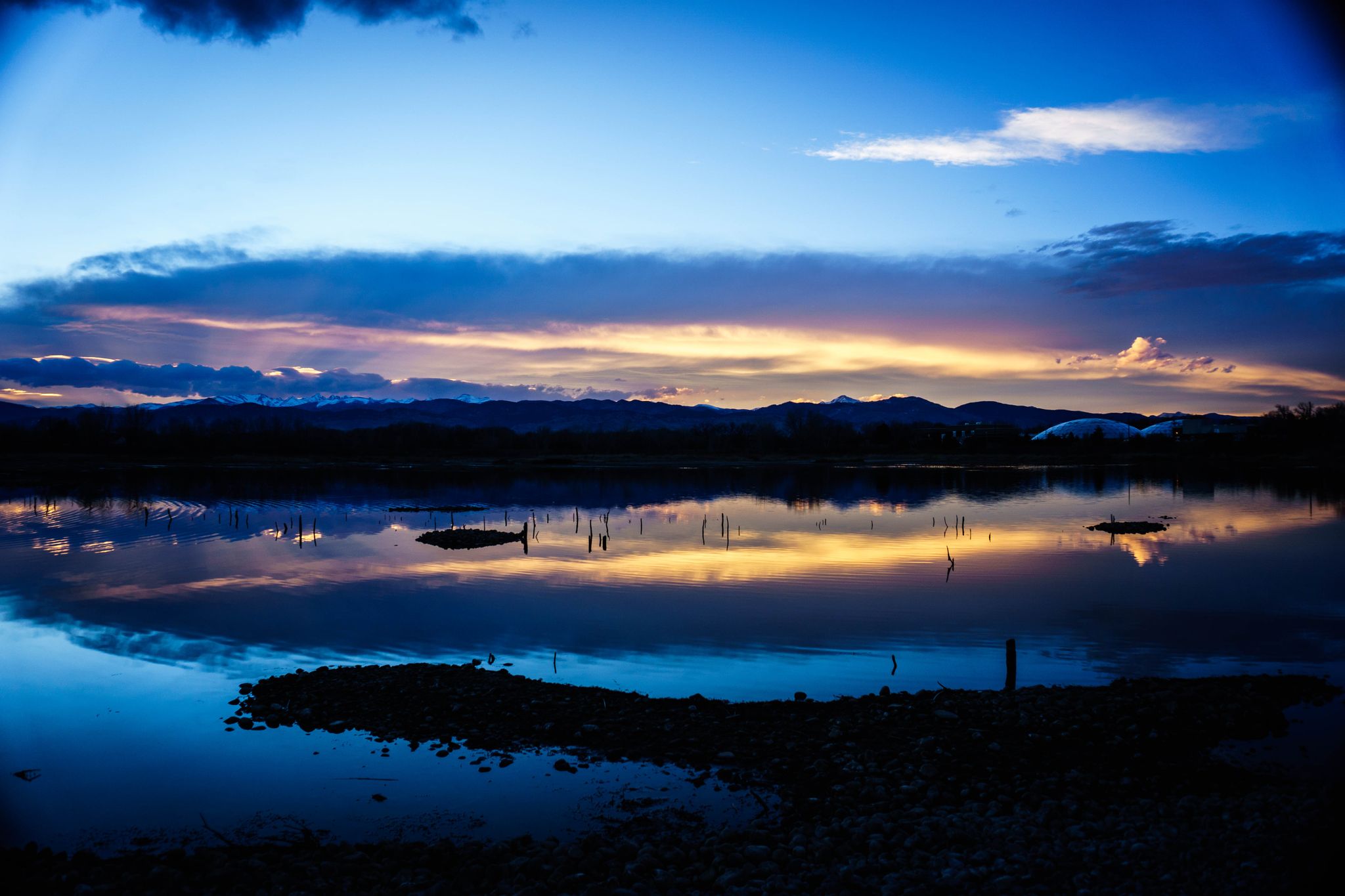 Vibrant sunset sky reflecting on calm water with dark hills in distance. - Sawhill and Walden Ponds Loop