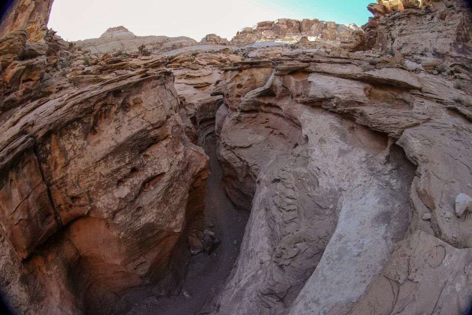 Fisheye view of a narrow, winding slot canyon with sculpted rock walls. - Ding and Dang Canyons Loop