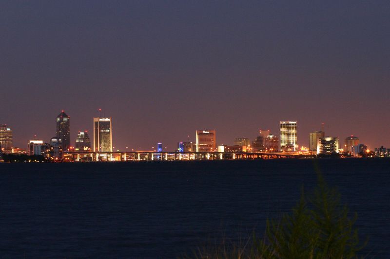 Illuminated city skyline across dark water at night. - Ortega Bridge – Fuller Warren Bridge loop from Venetia Village