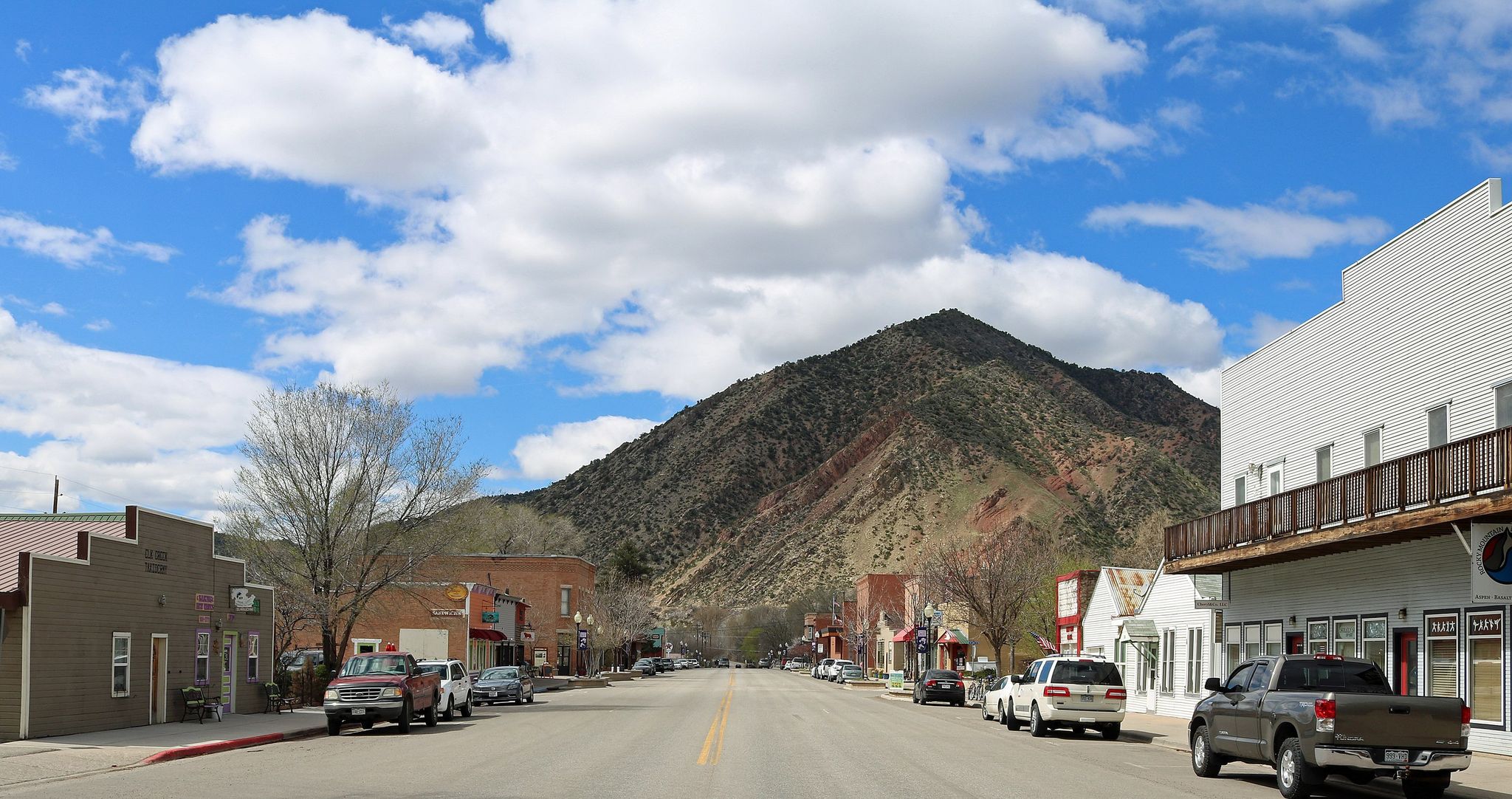 A small town street with buildings and a large mountain backdrop. - New Castle – Grass Valley Reservoir loop from New Castle