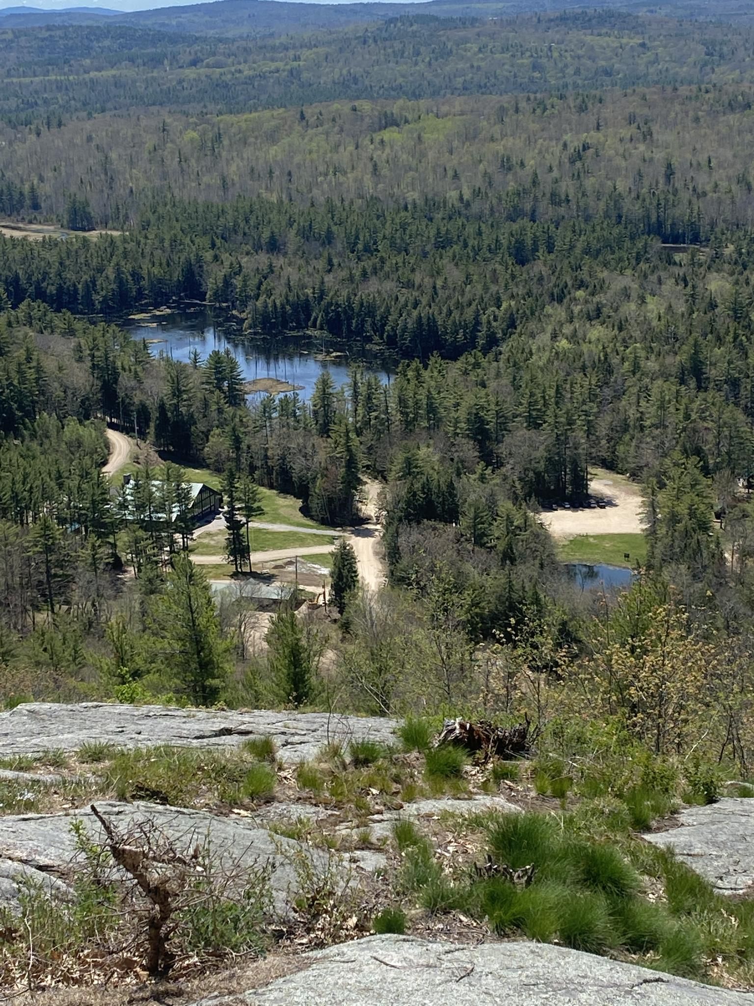 Sunny aerial view of a valley with a lake, buildings, and dense forests. - Mount Shannon Yellow Trail Loop