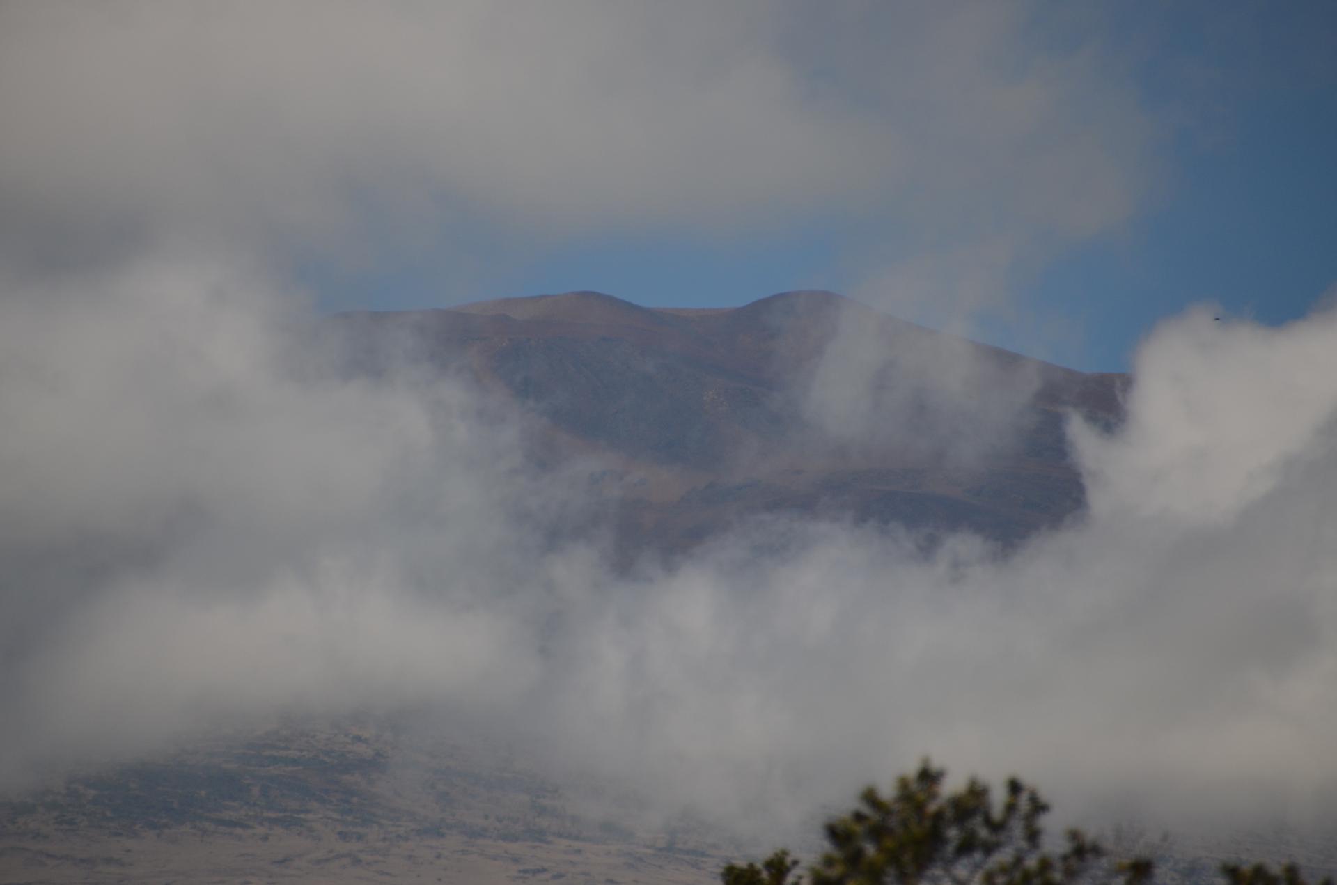 Distant mountain peaks partially obscured by thick, white clouds.