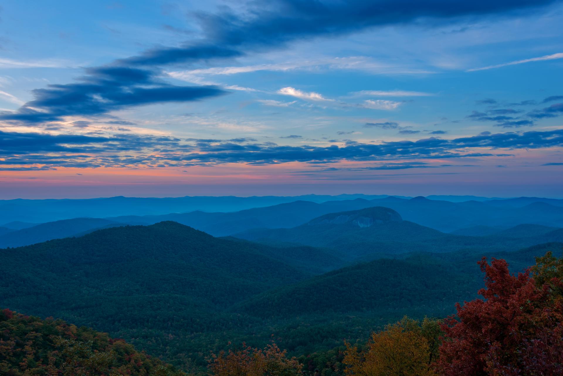 Vast mountain landscape at dusk with a colorful blue and pink sky.