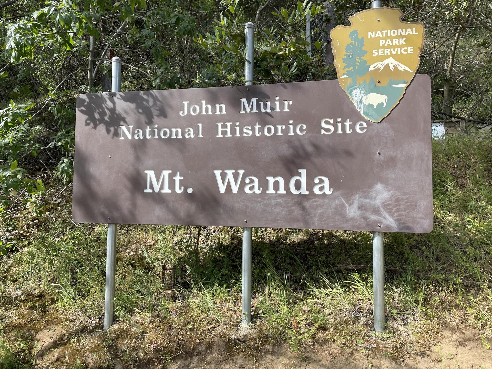 A brown park sign with white text and a national park emblem.