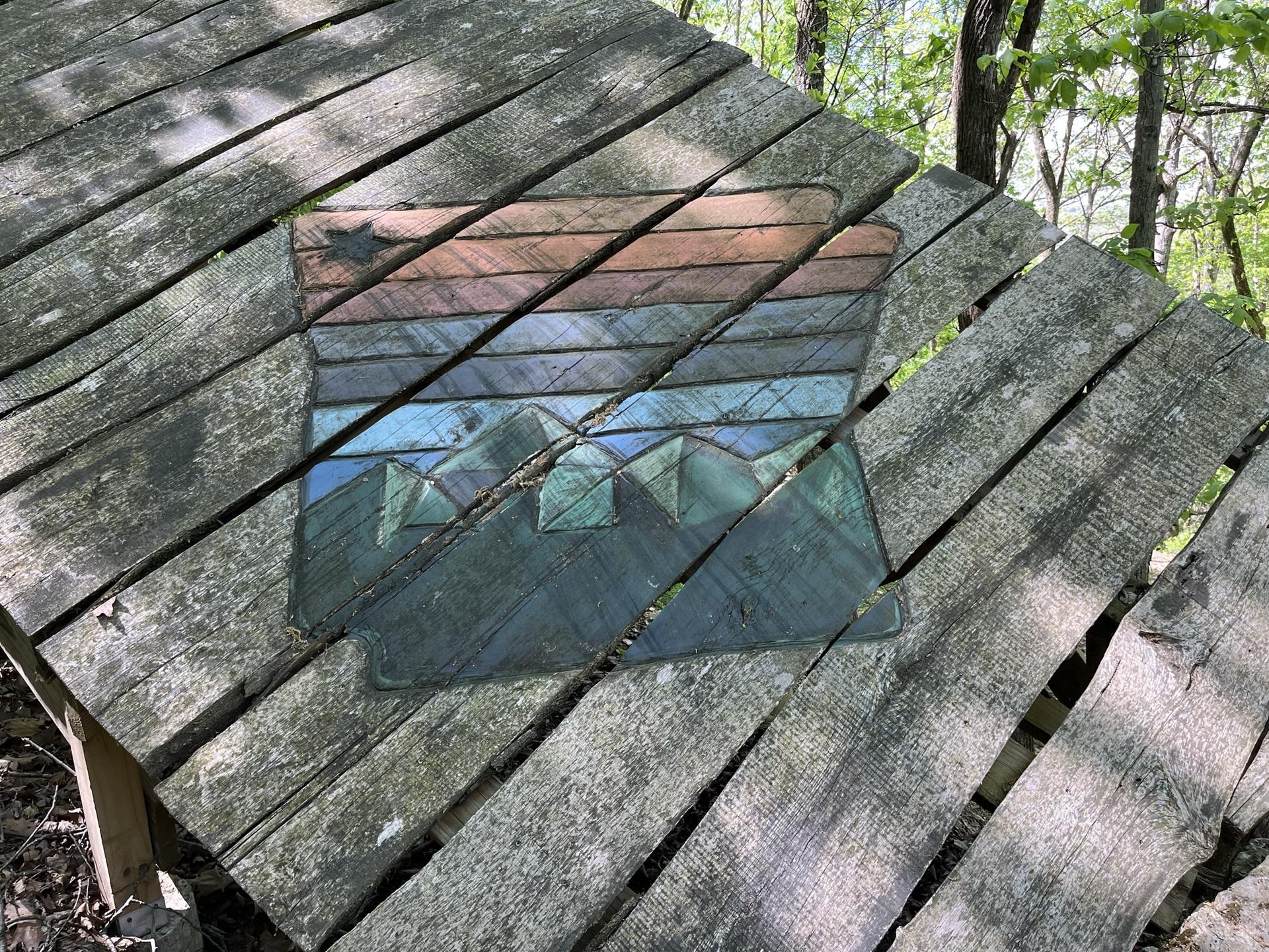 An abstract mountain design is embedded in a wooden plank surface.