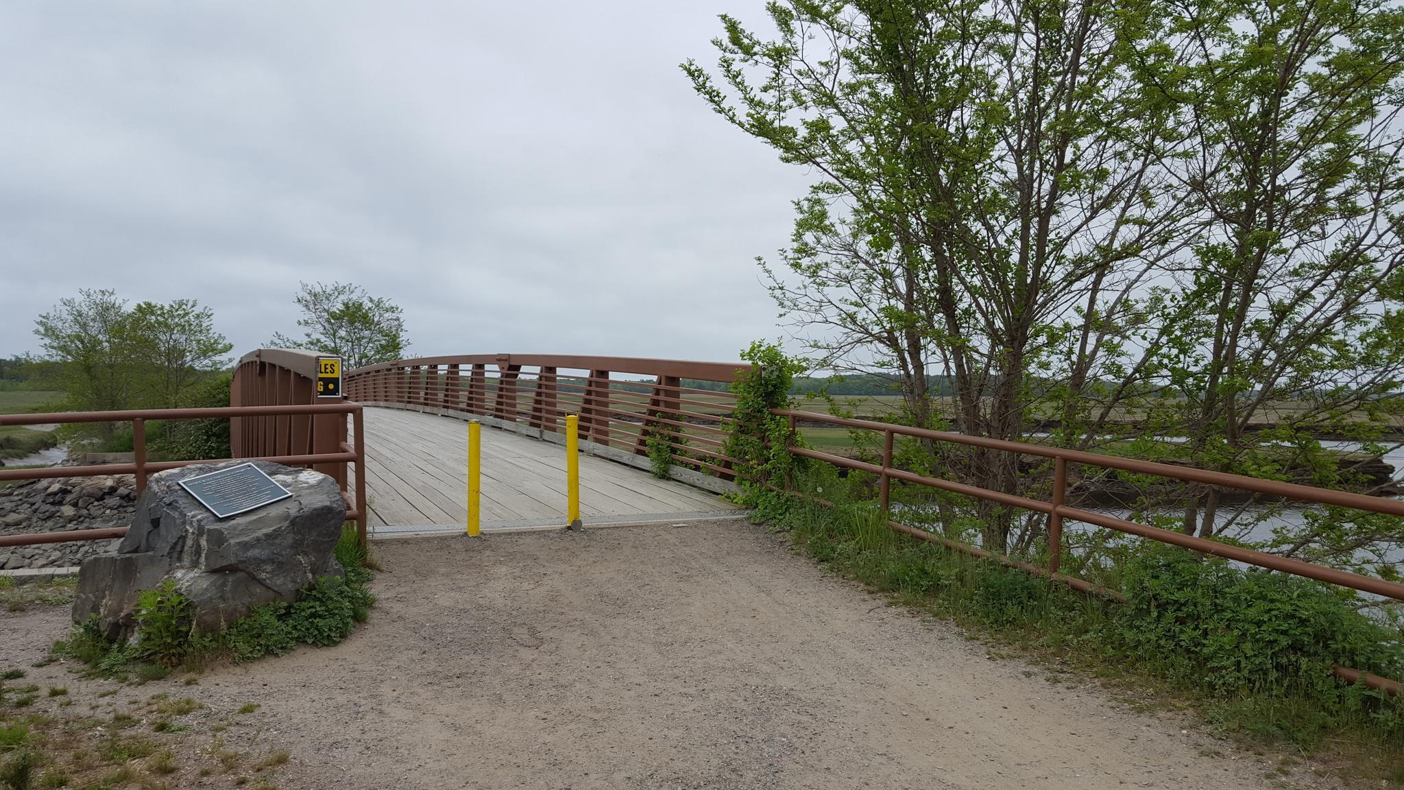 A wooden bridge over water under an overcast sky.