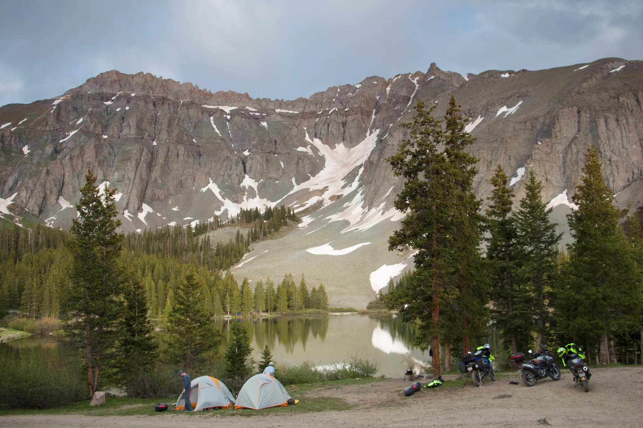 Two tents and motorcycles by a lake with majestic, snow-dusted mountains. - Alta Ghost Town OHV Trail