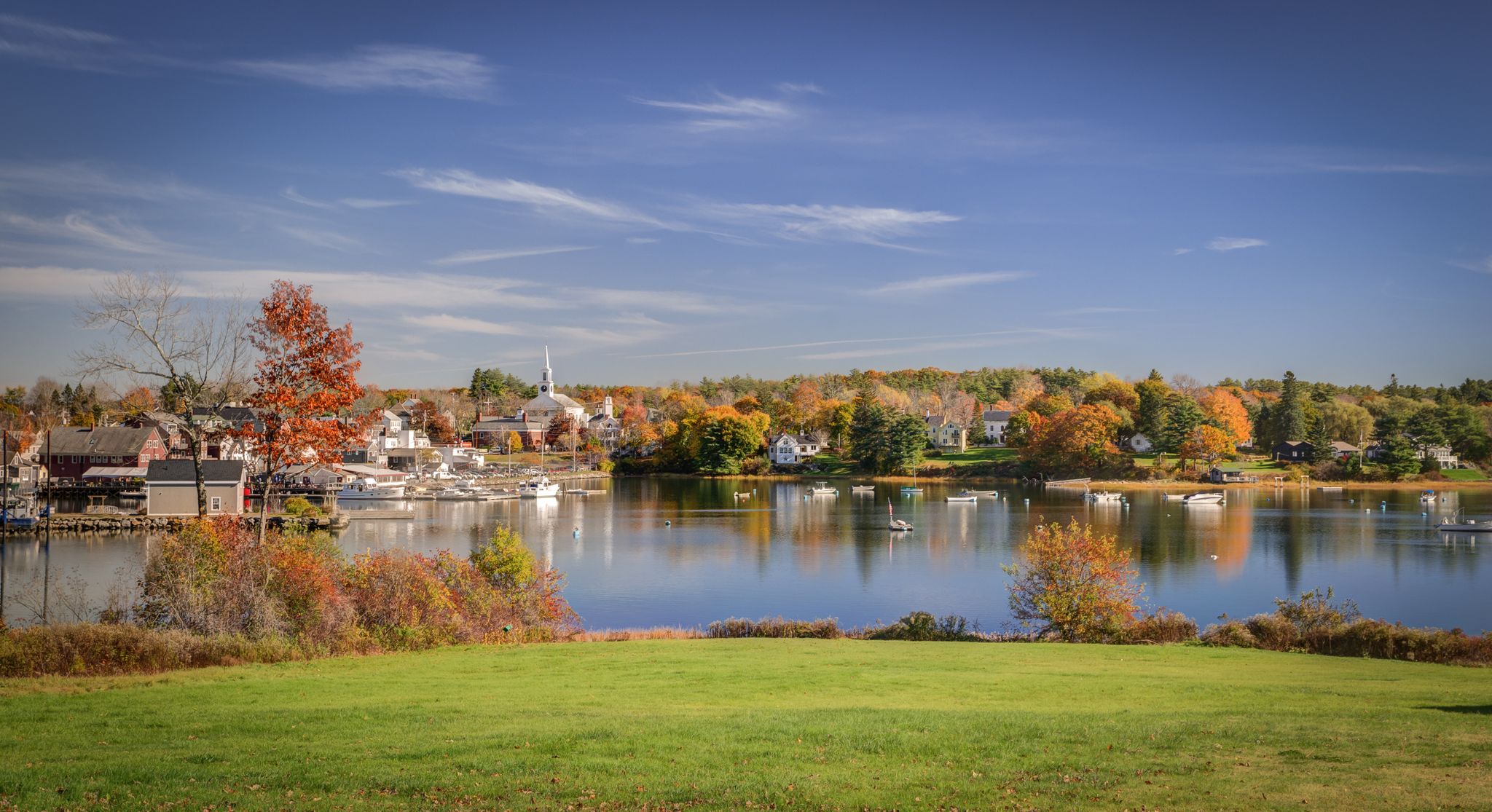 Scenic lake with a town and colorful autumn trees under a blue sky. - Twin Villages to Pemaquid Lighthouse & Fort William Henry loop