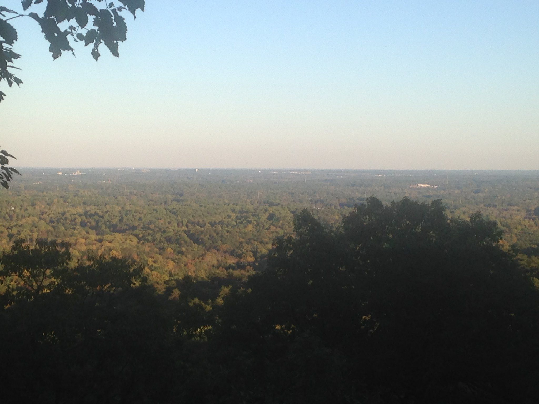A wide view of a vast, green forest under a clear, hazy sky. - Paris Mountain State Park – Brissy Ridge View loop from Paris Mountain State Park