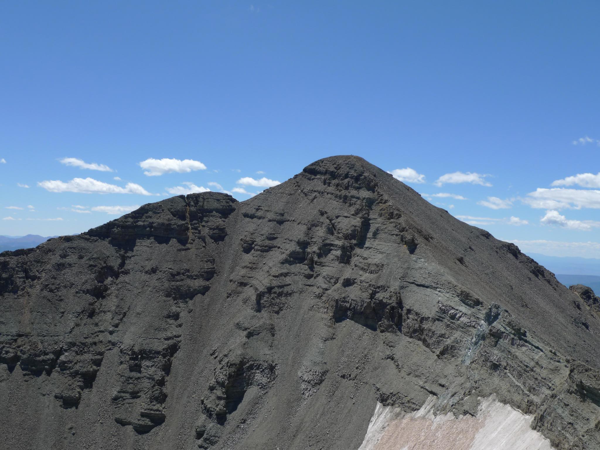 A rugged, dark mountain peak under a clear blue sky.