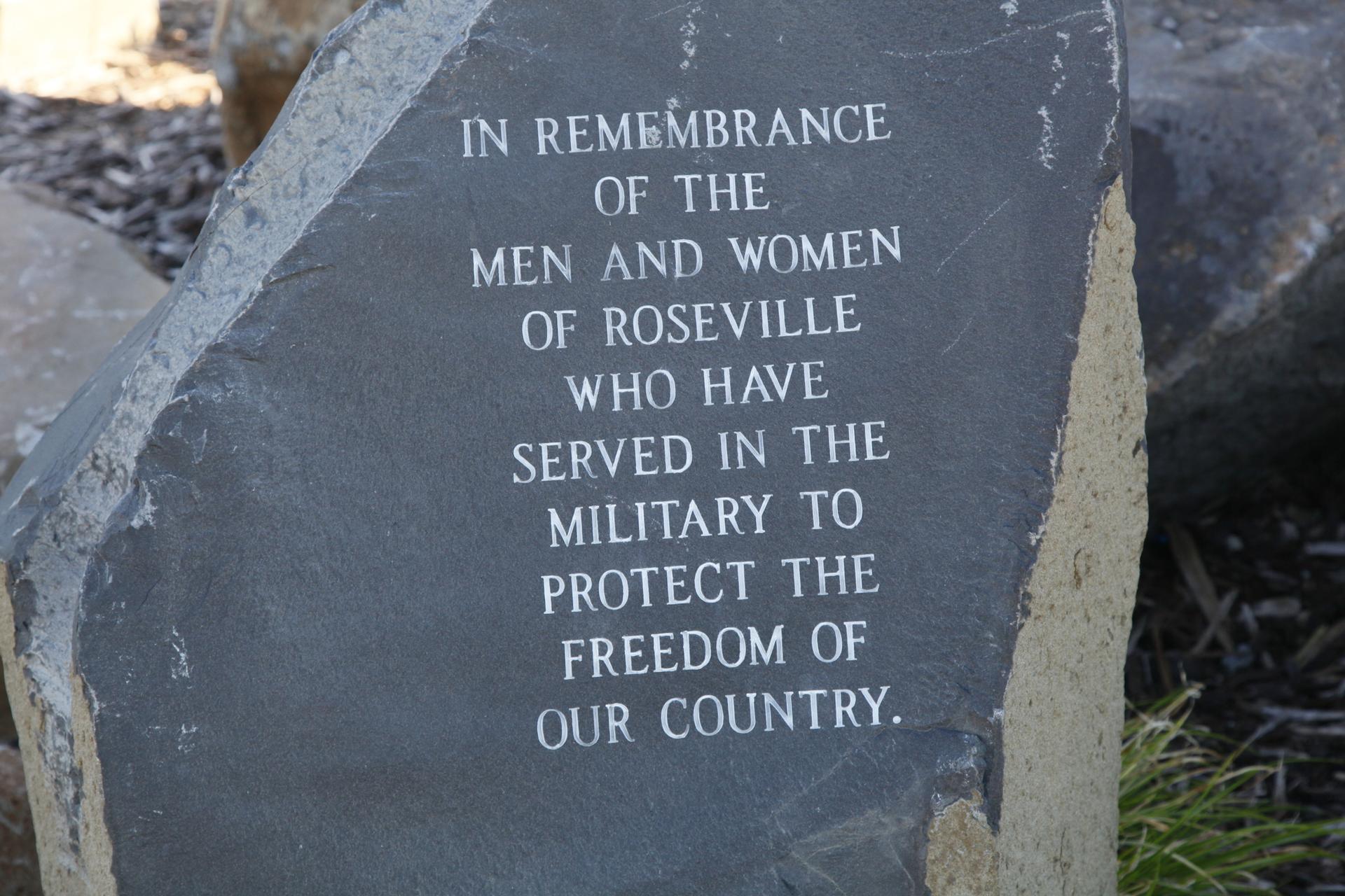 A close-up of a dark stone monument with white engraved text.