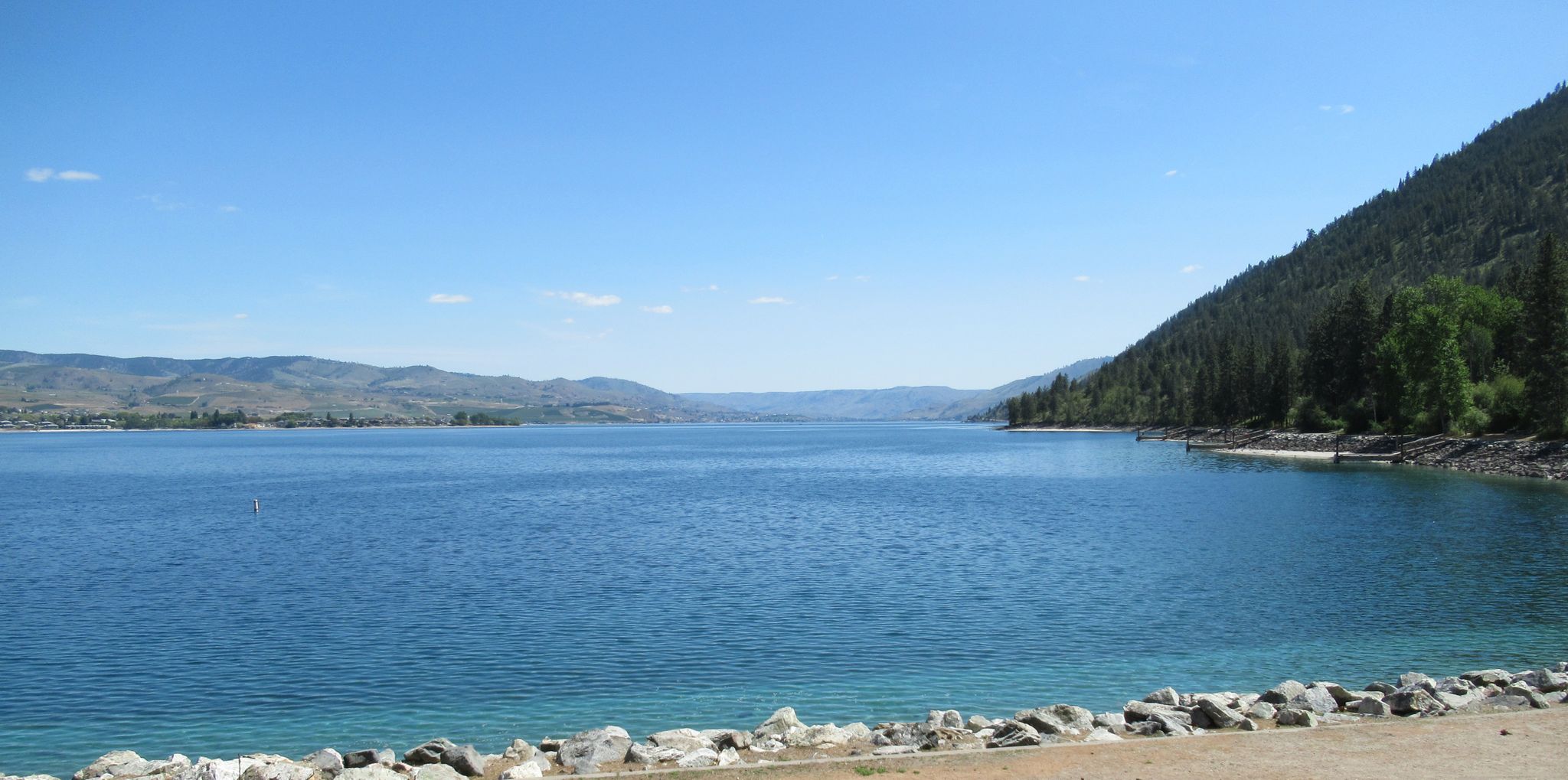 Expansive blue lake bordered by mountains and a forested slope on a sunny day. - Don Morse Memorial Park – Lake Chelan State Park loop from Chelan