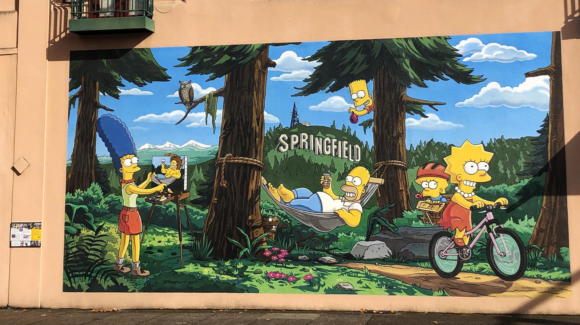Colorful mural of cartoon characters enjoying outdoor activities in a sunny forest.