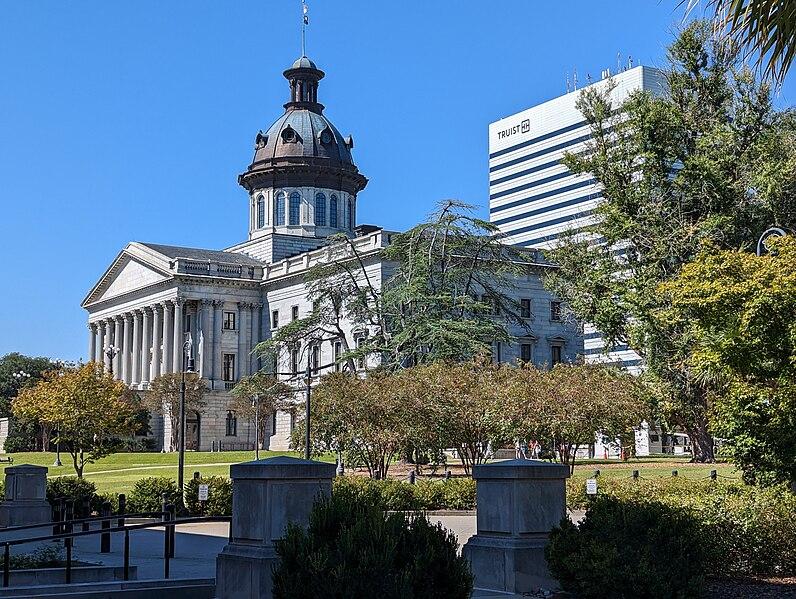 Domed building and modern high-rise under a clear blue sky.