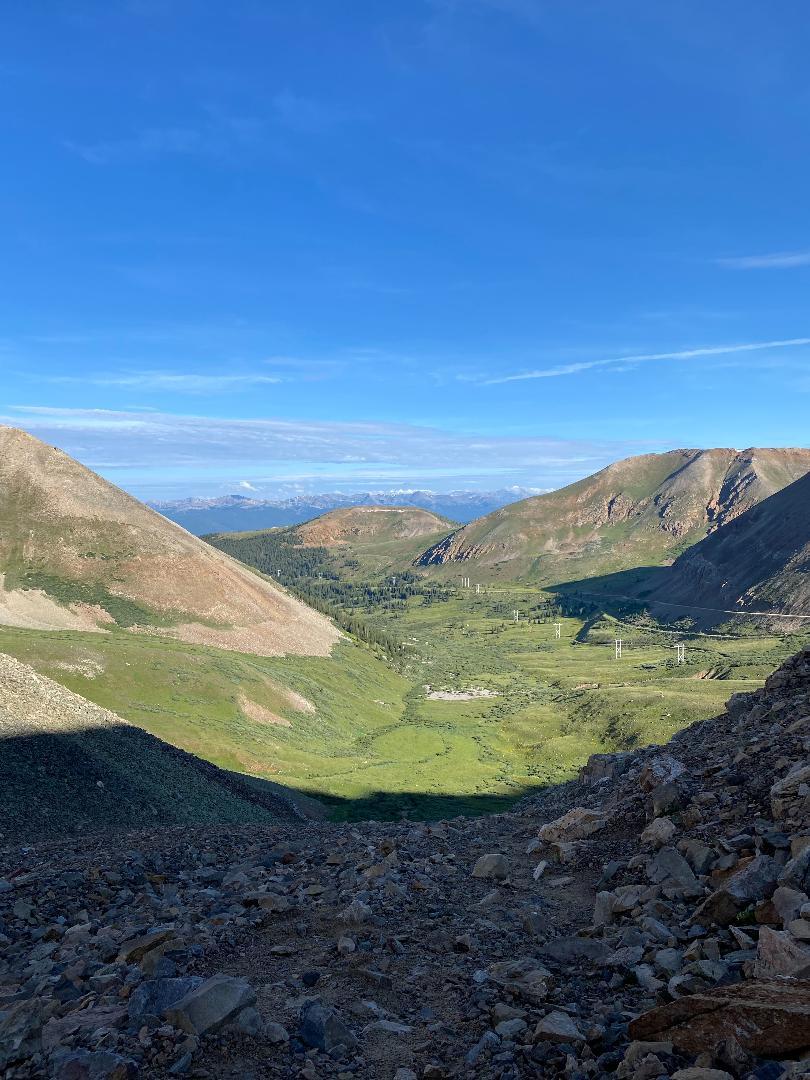 Deep mountain valley with steep rocky slopes and a lush green floor.