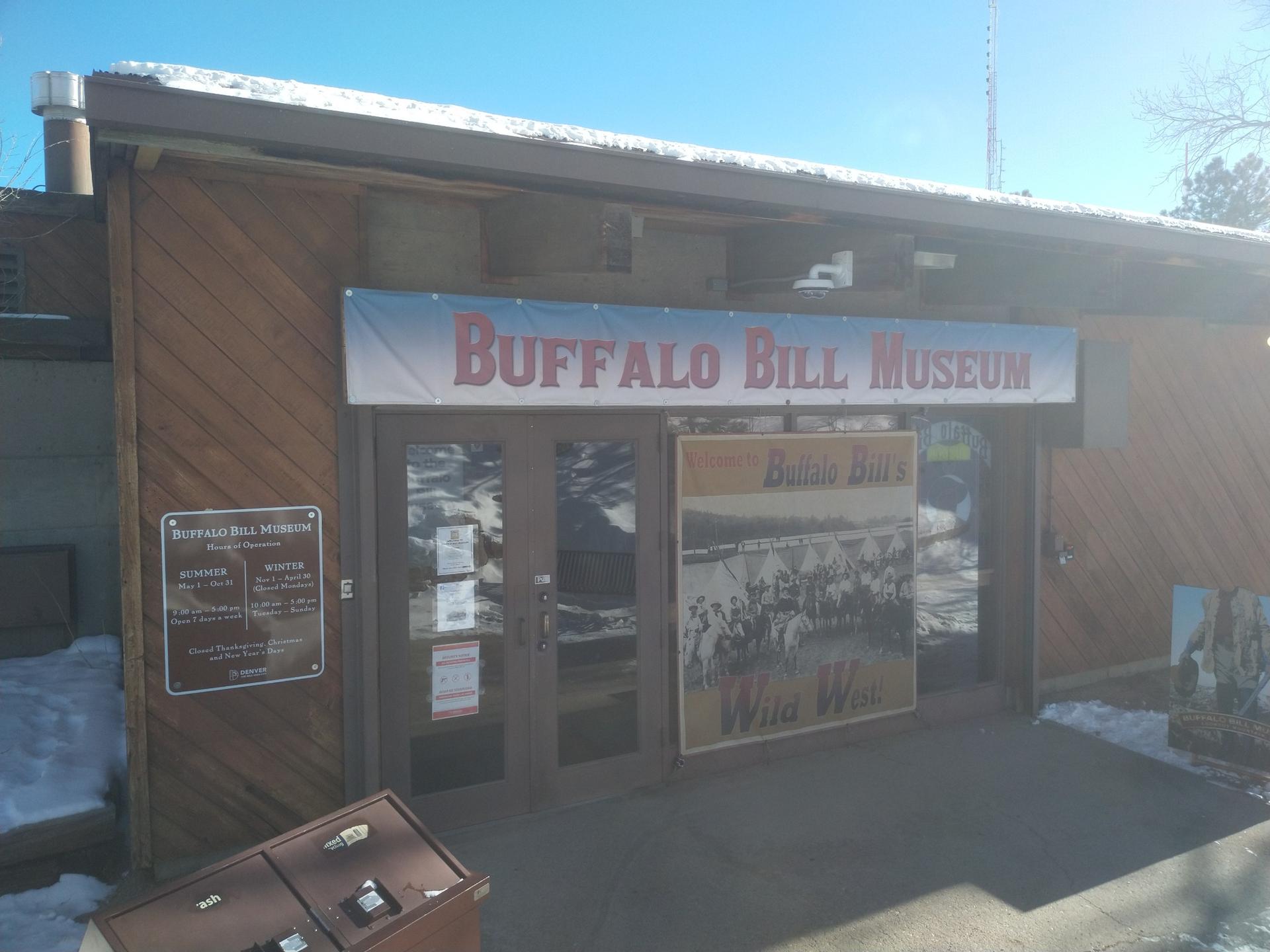 Building entrance with a large banner and snow on the ground.