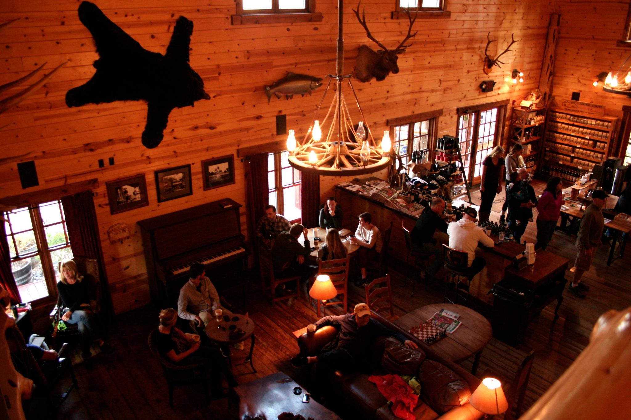 Overhead view of a rustic lodge interior with people, warm lighting, and taxidermy.
