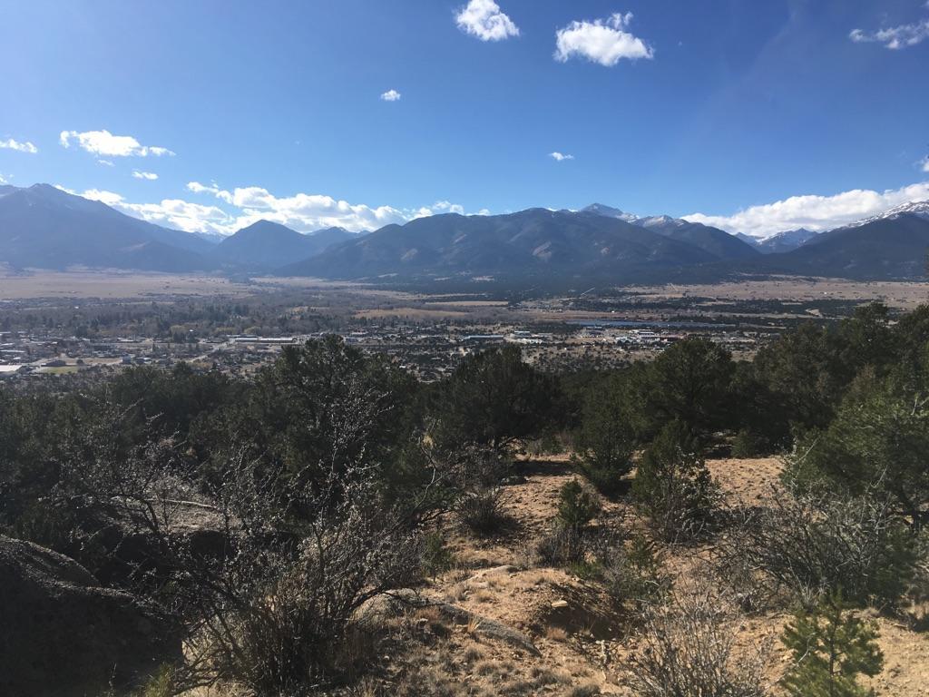 Sunny panoramic view of a valley town surrounded by mountains.