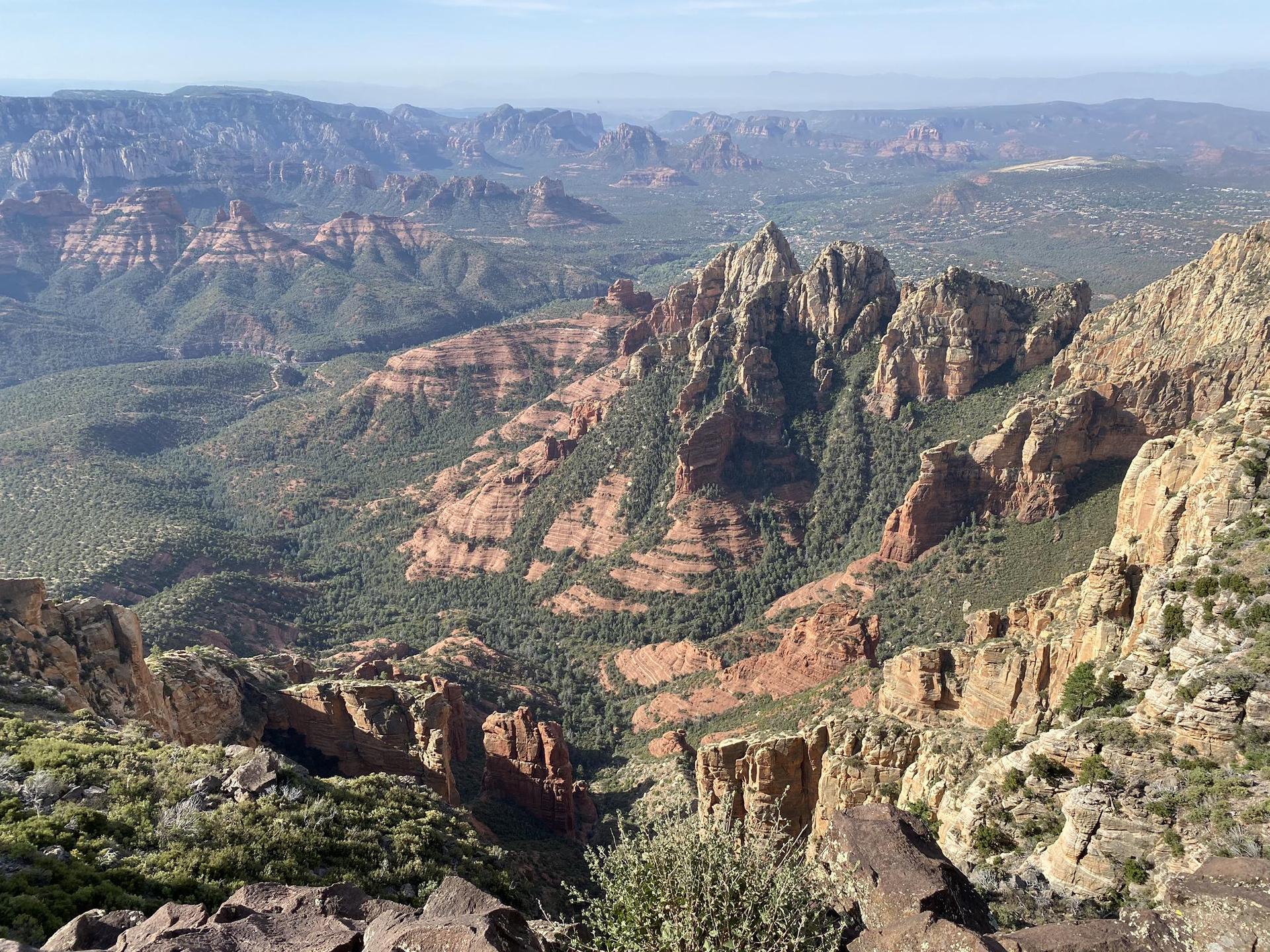 Panoramic view of vast, rugged mountains and canyons under a clear sky.