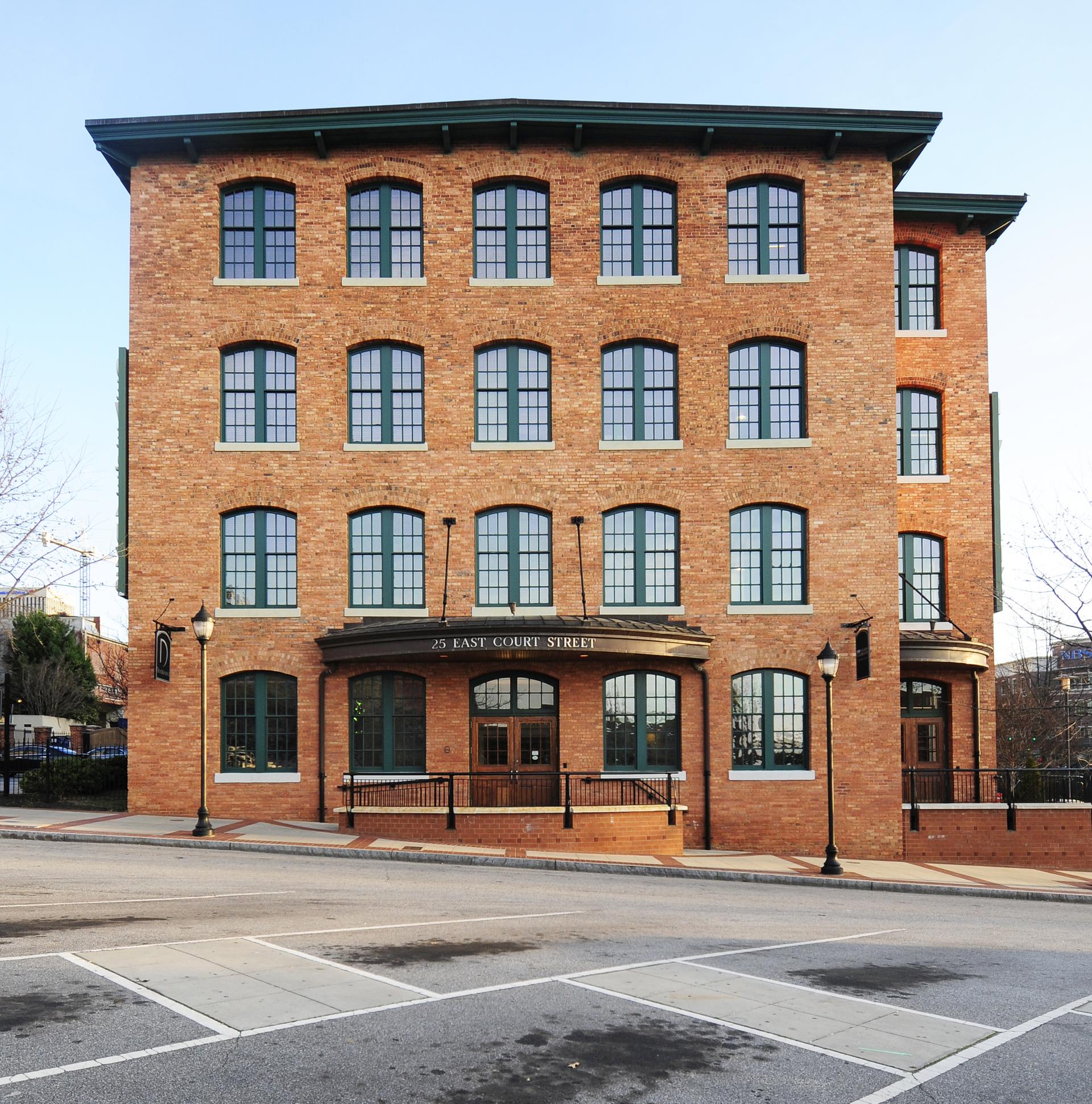 Front view of a multi-story brick building with many windows on a clear day.