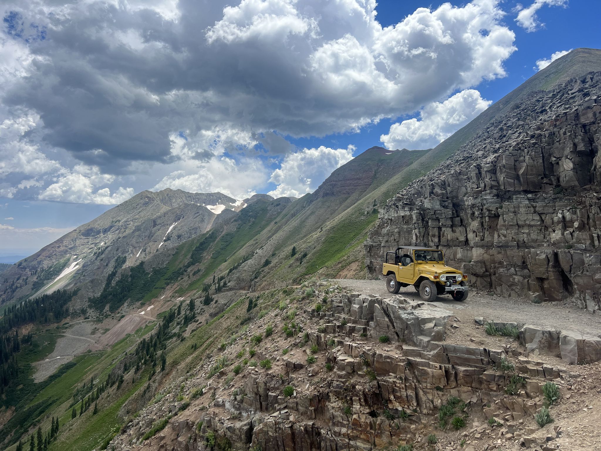 Yellow off-road vehicle on a narrow, rocky mountain trail under cloudy skies. - La Plata Canyon Road