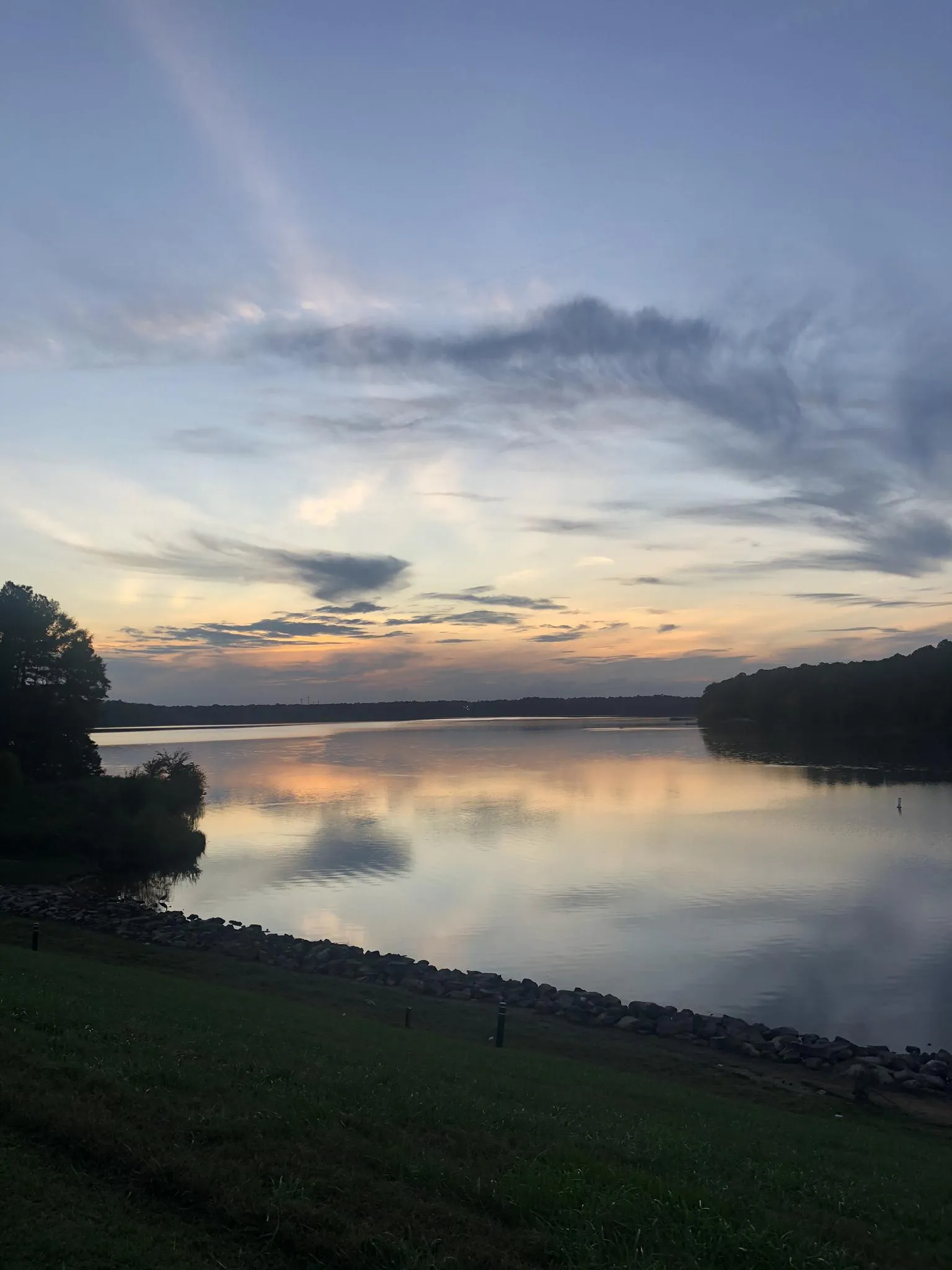 Serene lake at dusk, reflecting colorful clouds and dark shorelines. - Lake Crabtree – Lake Crabtree loop from Lake Crabtree Dam
