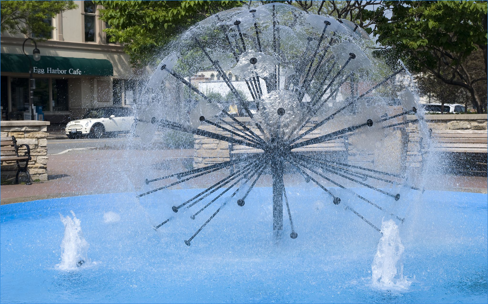 Large spherical water fountain spraying in an urban setting. - West Branch DuPage River Trail Loop