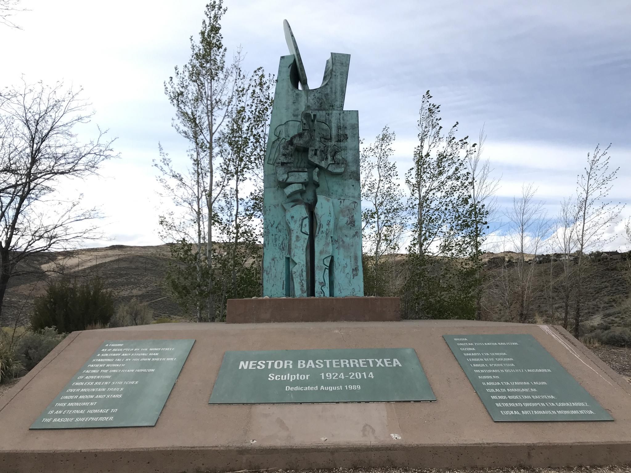Abstract bronze sculpture on a concrete base under a bright sky. - Evans Canyon and Keystone Canyon Loop