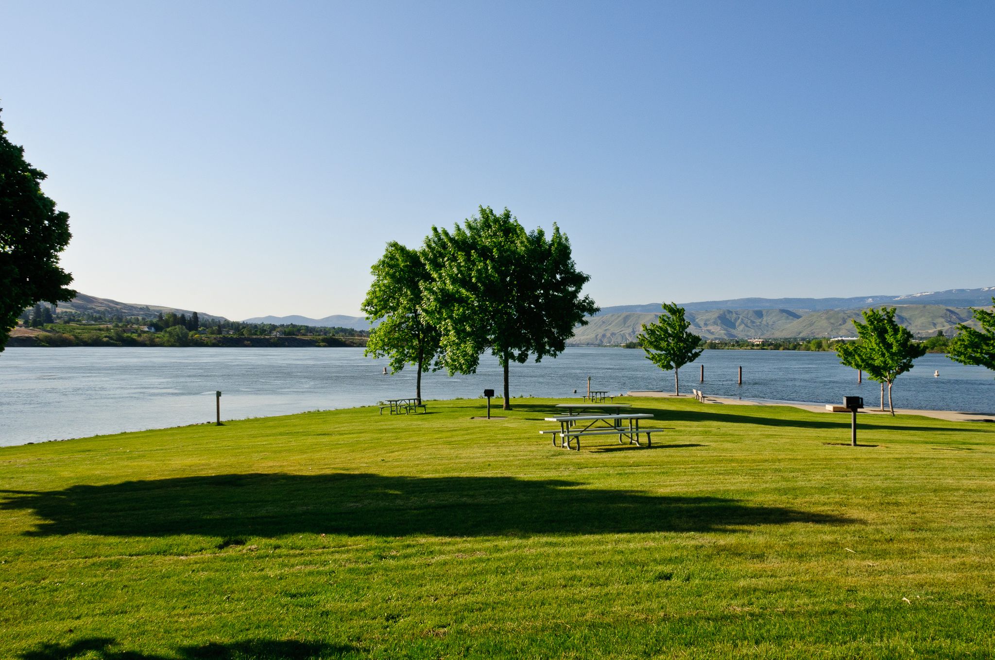 Grassy park with picnic tables by a lake, green trees, sunny day. - Riverfront Park – Walla Walla Point Park loop from Wenatchee
