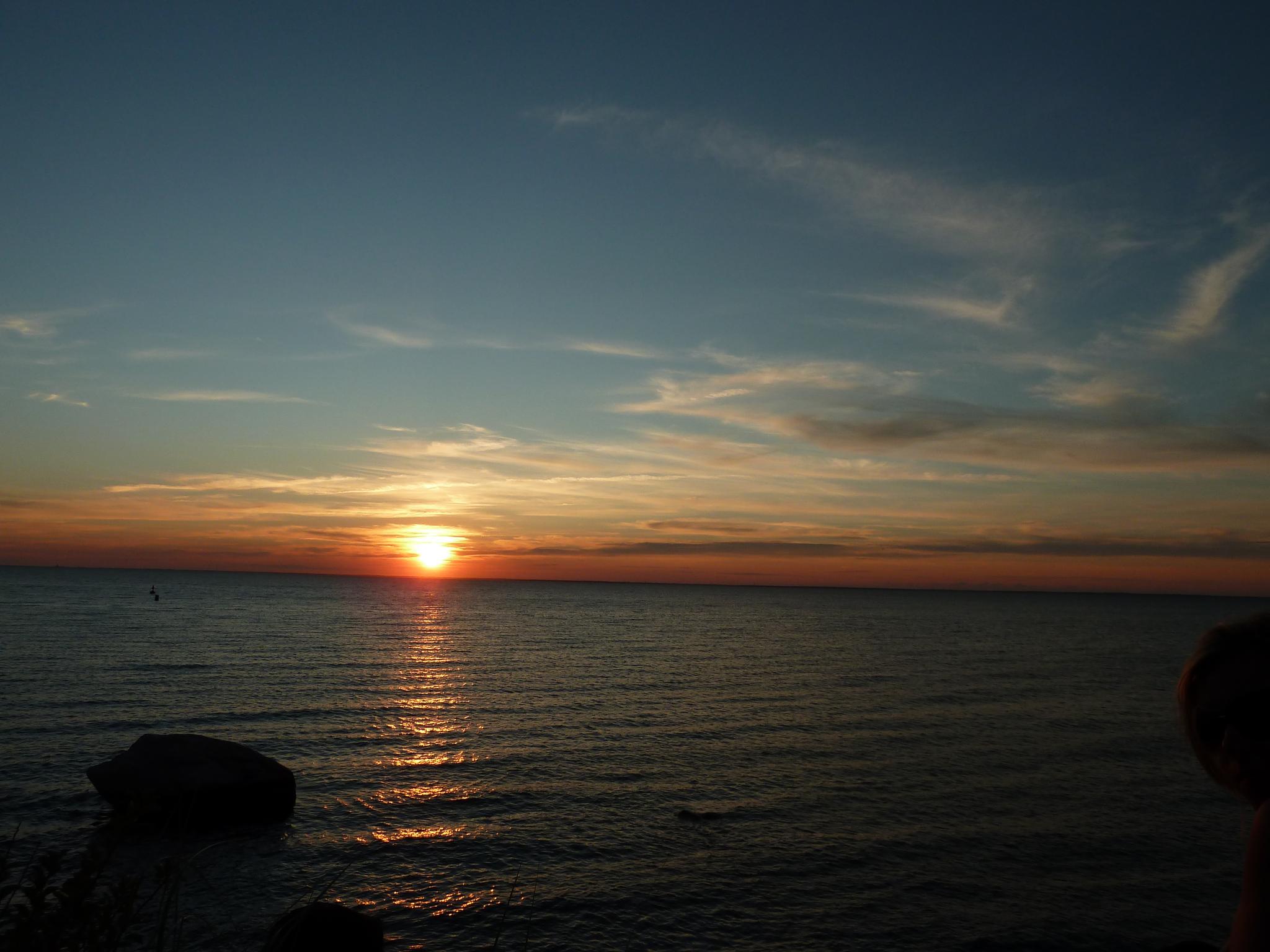 Vibrant sunset over a calm ocean with a golden reflection on the water.