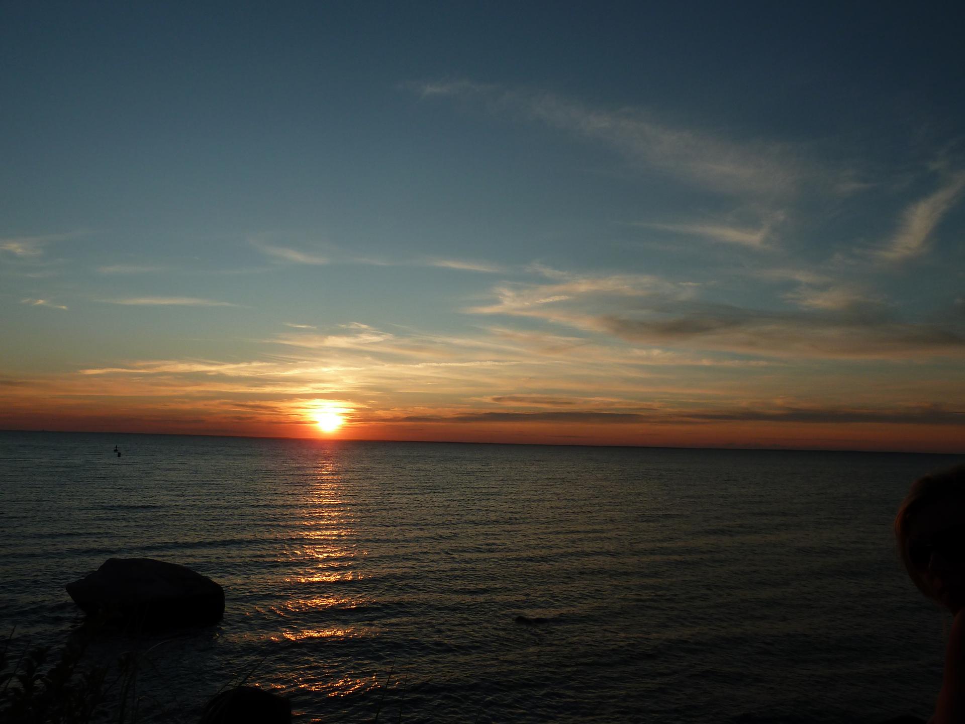 Vibrant sunset over a calm ocean with a golden reflection on the water.