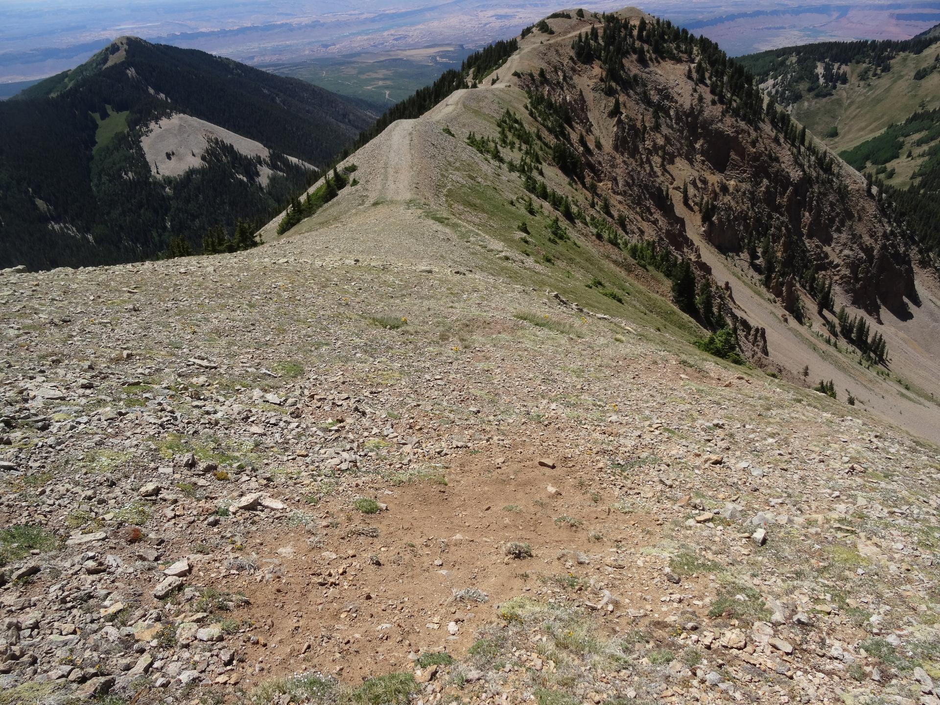 A rocky, barren mountain ridge stretching into the distance under a bright sky.