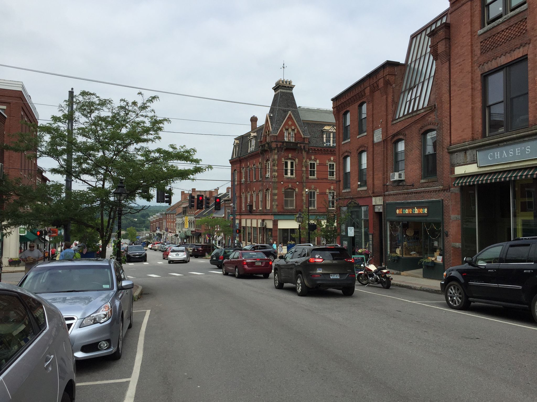 Busy city street with historic brick buildings and parked cars on an overcast day. - Belfast to Lake St. George loop