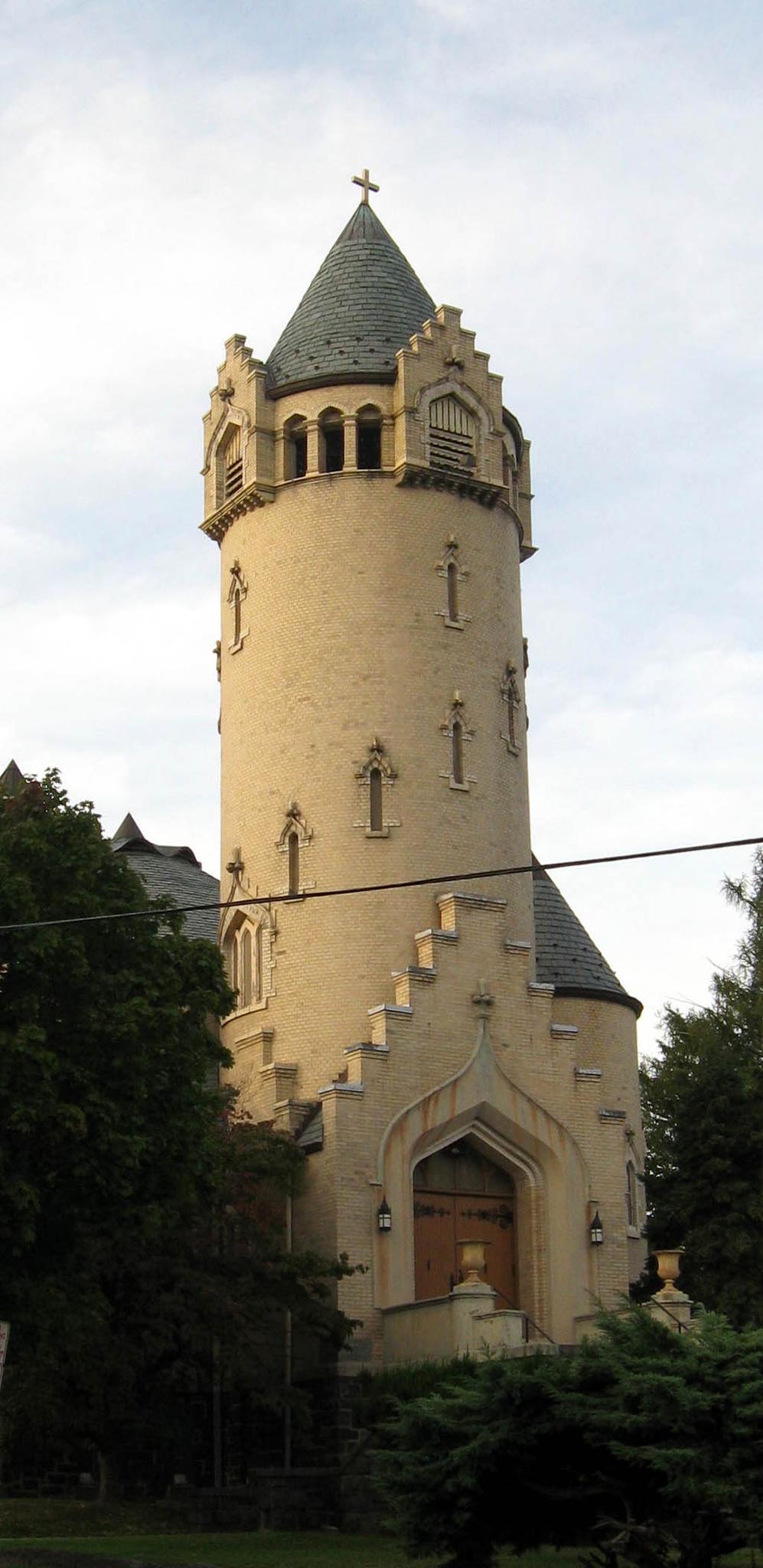 Tall, ornate stone tower with a pointed roof and small windows.