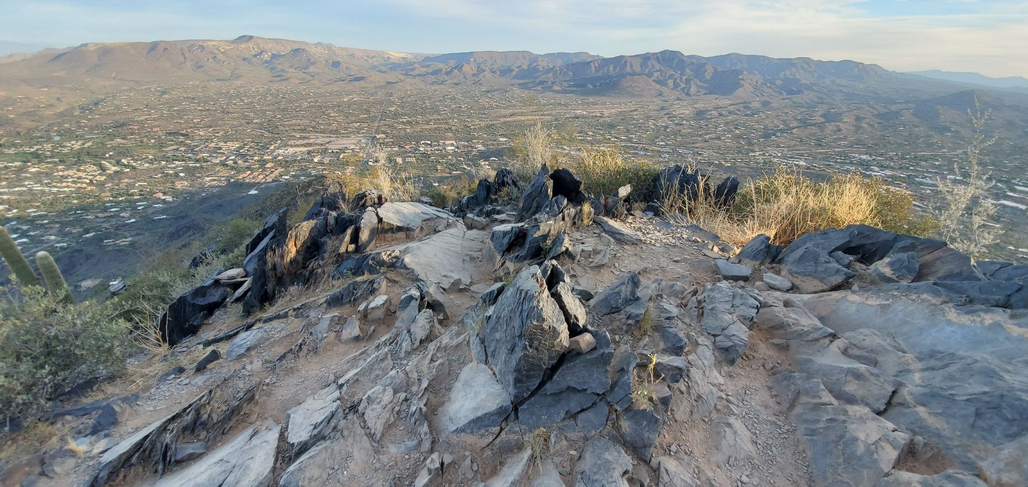 Rocky mountain summit at golden hour, overlooking a sprawling valley. - Black Mountain Trail