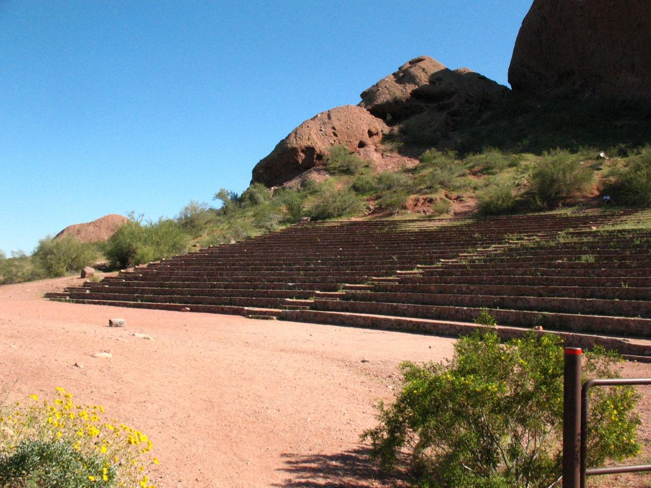 Wide stone steps ascend a red dirt hill under a clear sky.