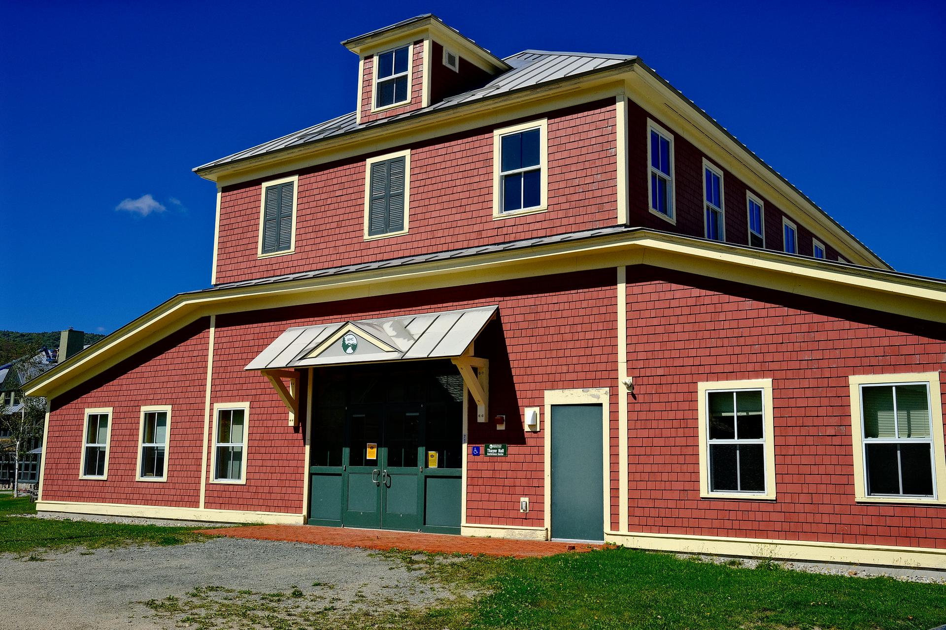 A large red building with many windows under a clear blue sky.