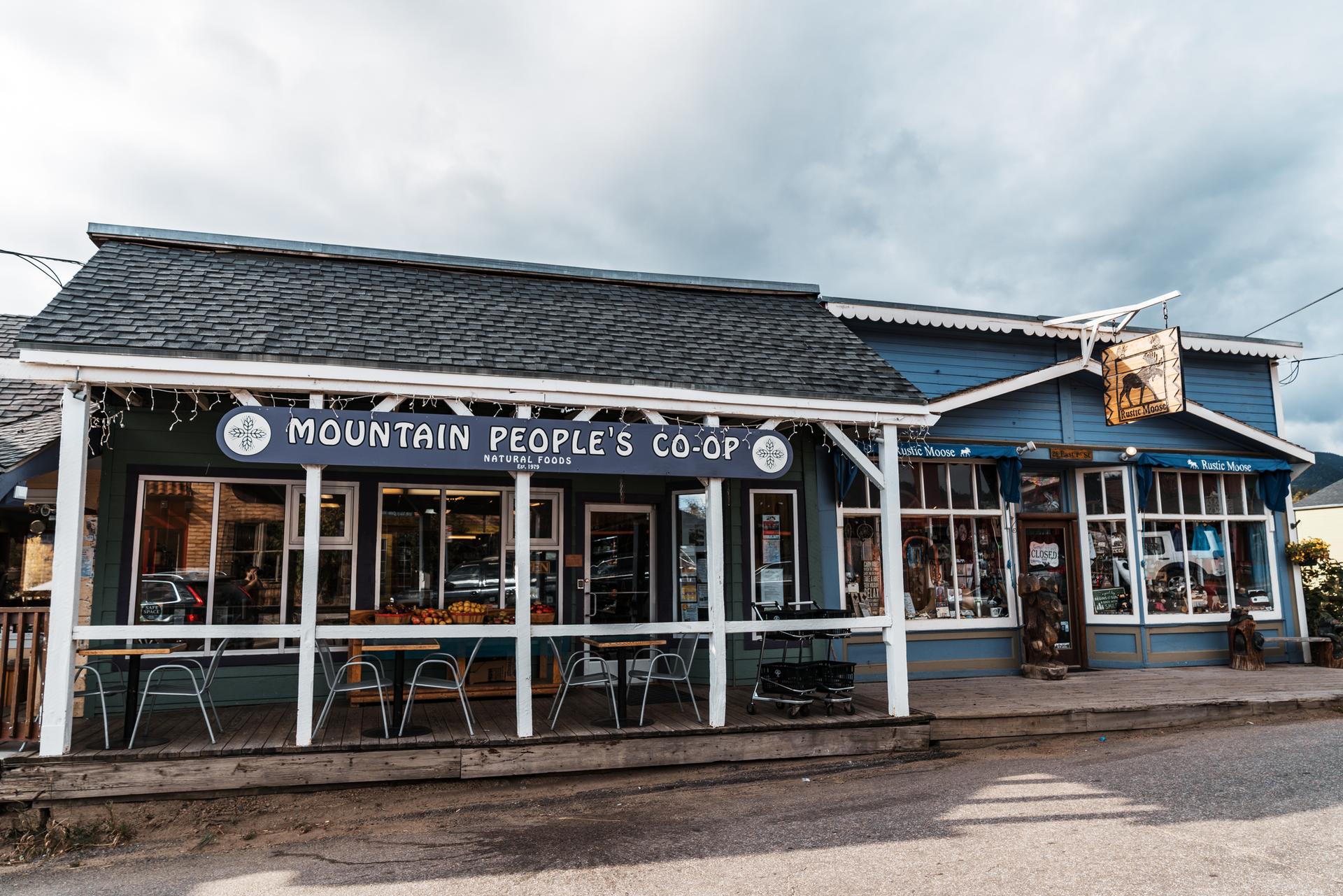 Blue storefront building with "Mountain People's Co-op" sign under an overcast sky.