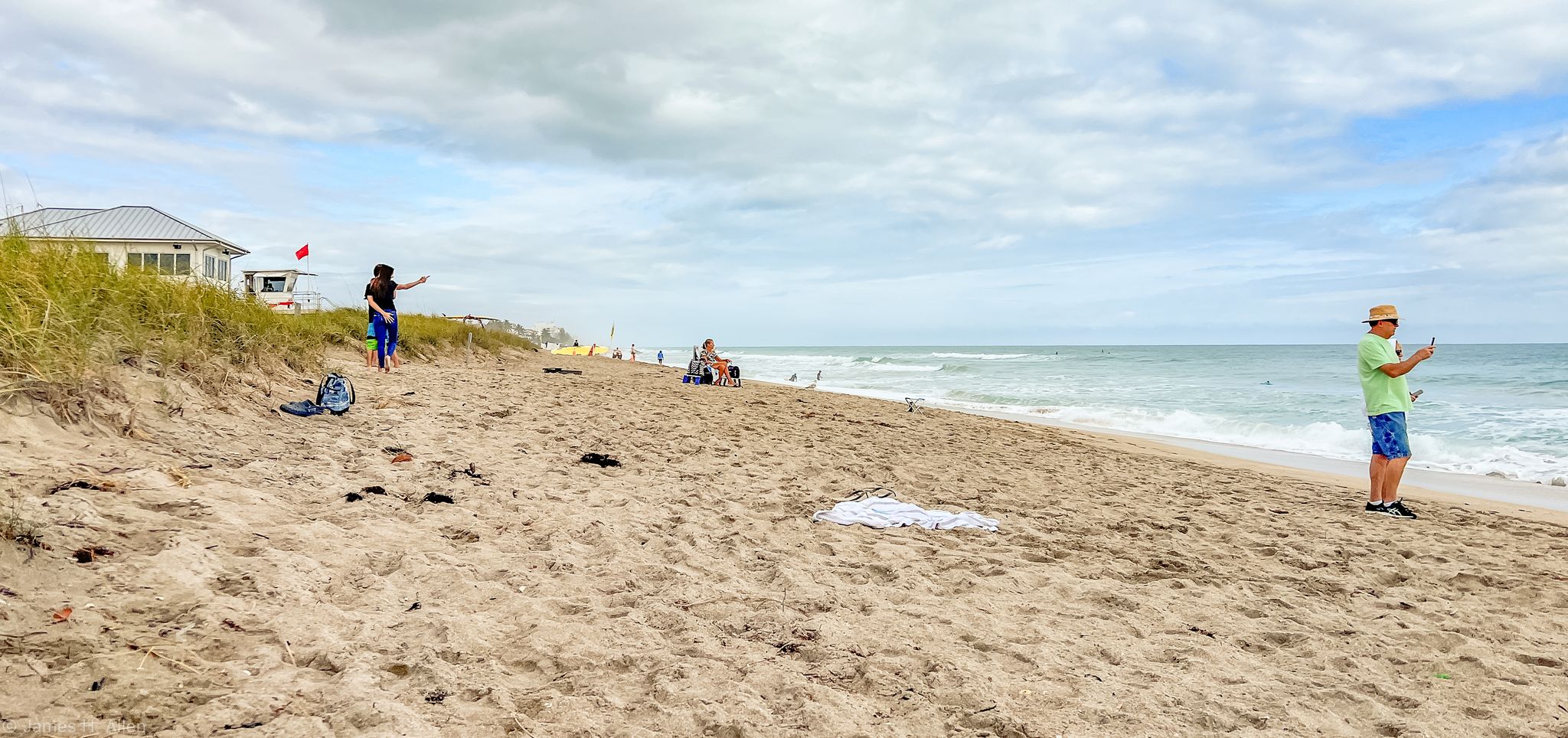 People enjoying a wide sandy beach with ocean waves under a cloudy sky. - Jensen Beach Park – Jensen Beach Park loop from Jensen Beach